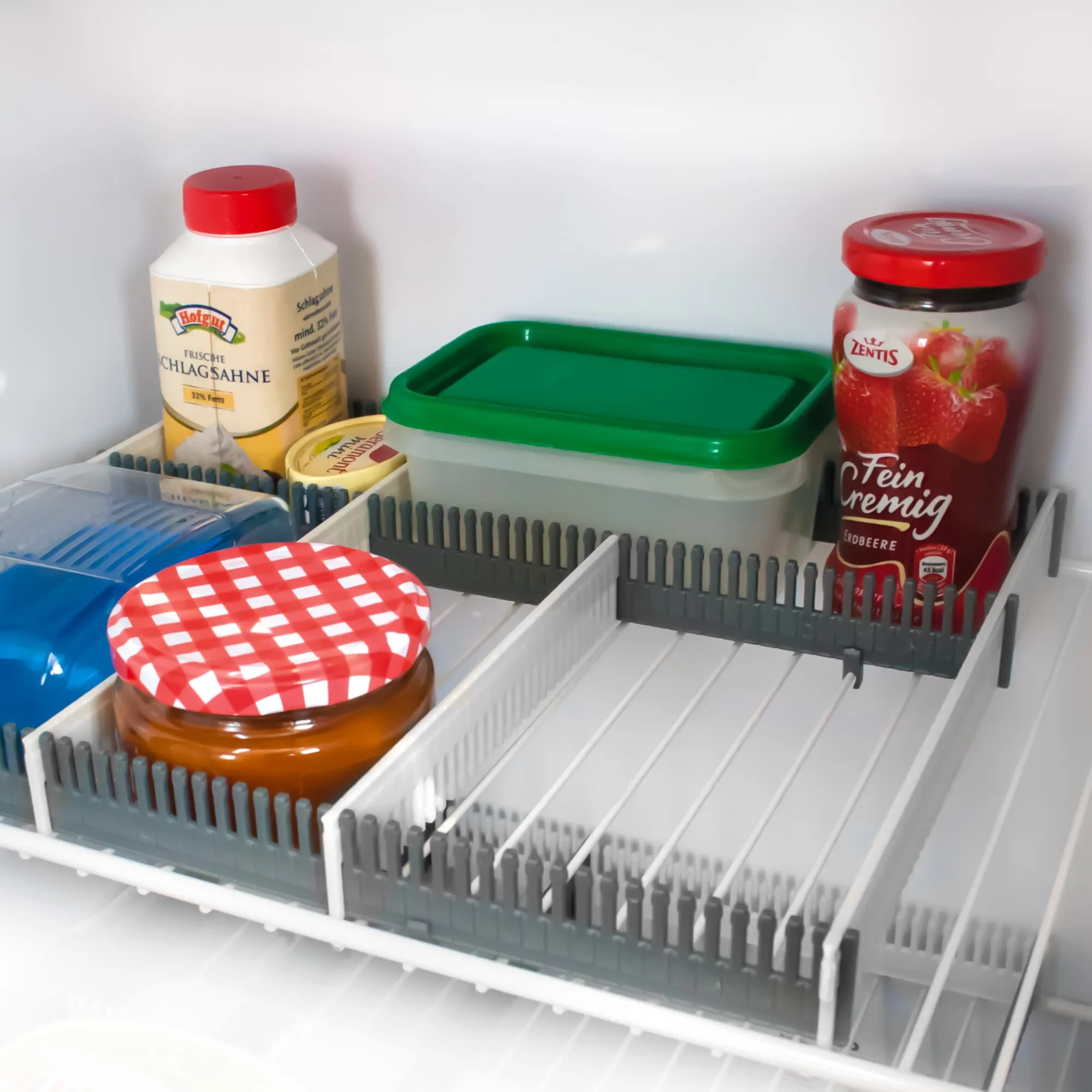 Hellgraue Stauleiste im Kühlschrank als senkrechte Begrenzung eines Fachs mit verschiedenen Lebensmitteln