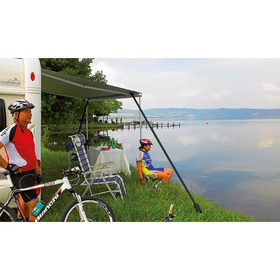 Thule Hold Down Kit zur Markisenabspannung am Wohnmobil mit schwarzen Spannbändern und Erdankern am Seeufer