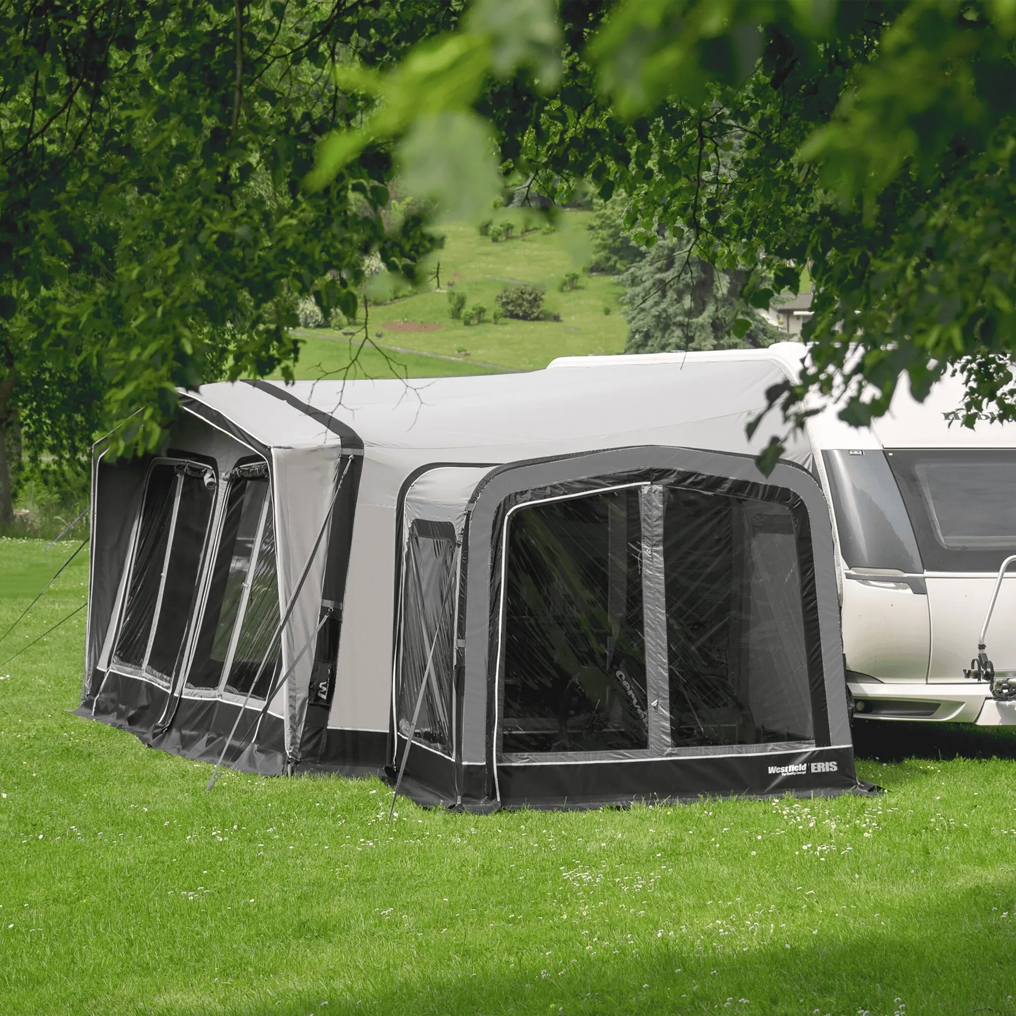 Graues Anbauzelt Eris mit großen Fensterflächen, befestigt an einem Wohnwagen auf einer grünen Wiese＿亚洲
