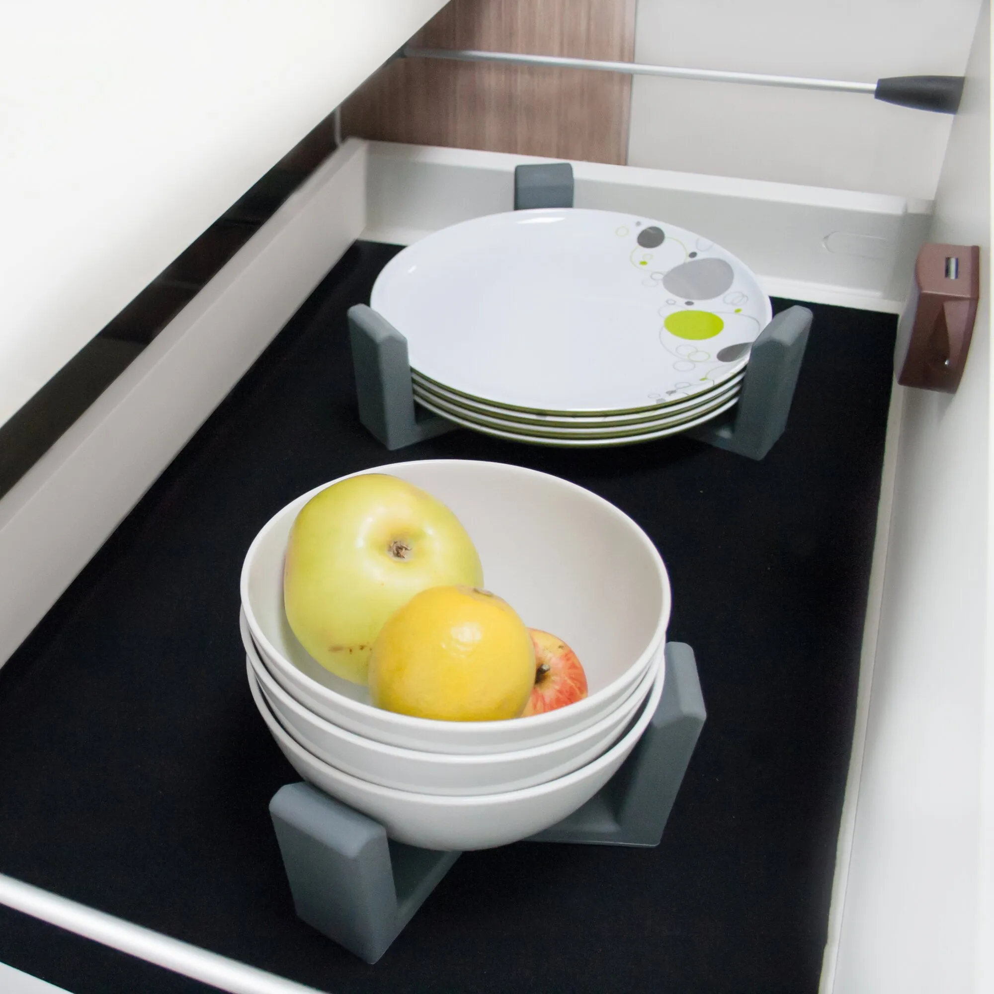 Vario System Modul III in einer Küchenschublade mit grauen Halterungen für Tellerstapel und einer Obstschale
