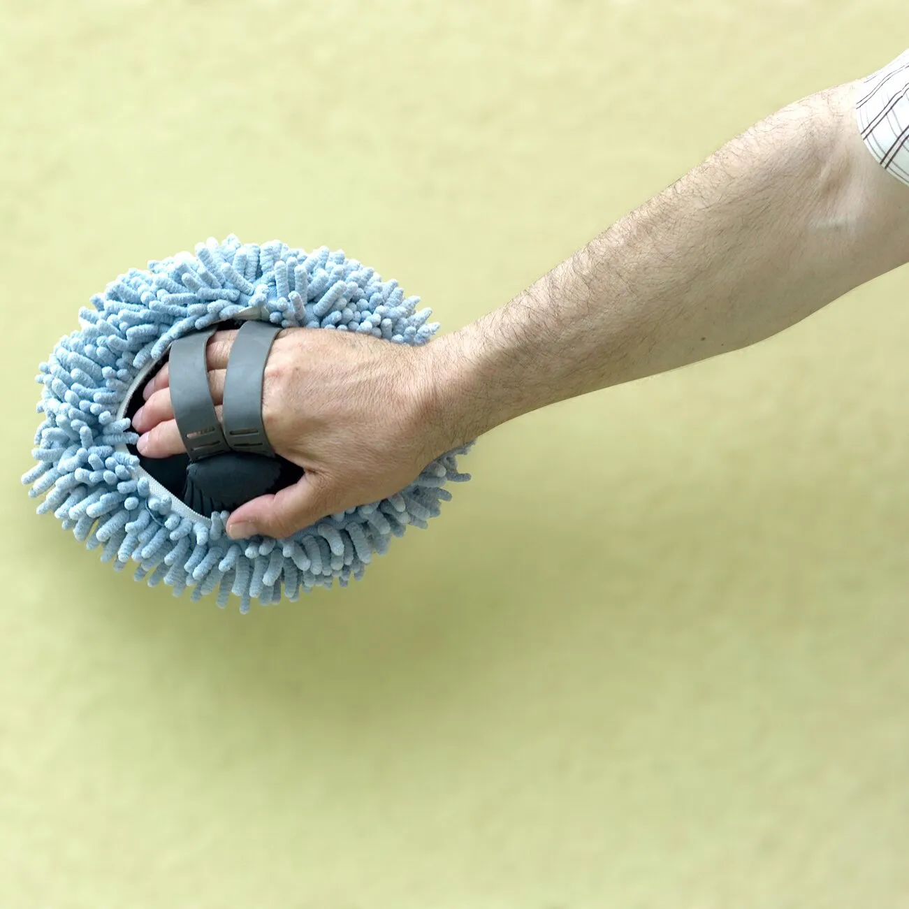 Hand hält einen runden, hellblauen Mikrofaser-Wischmopp Micro mit dichtem Chenillefaserkopf am Griff qen