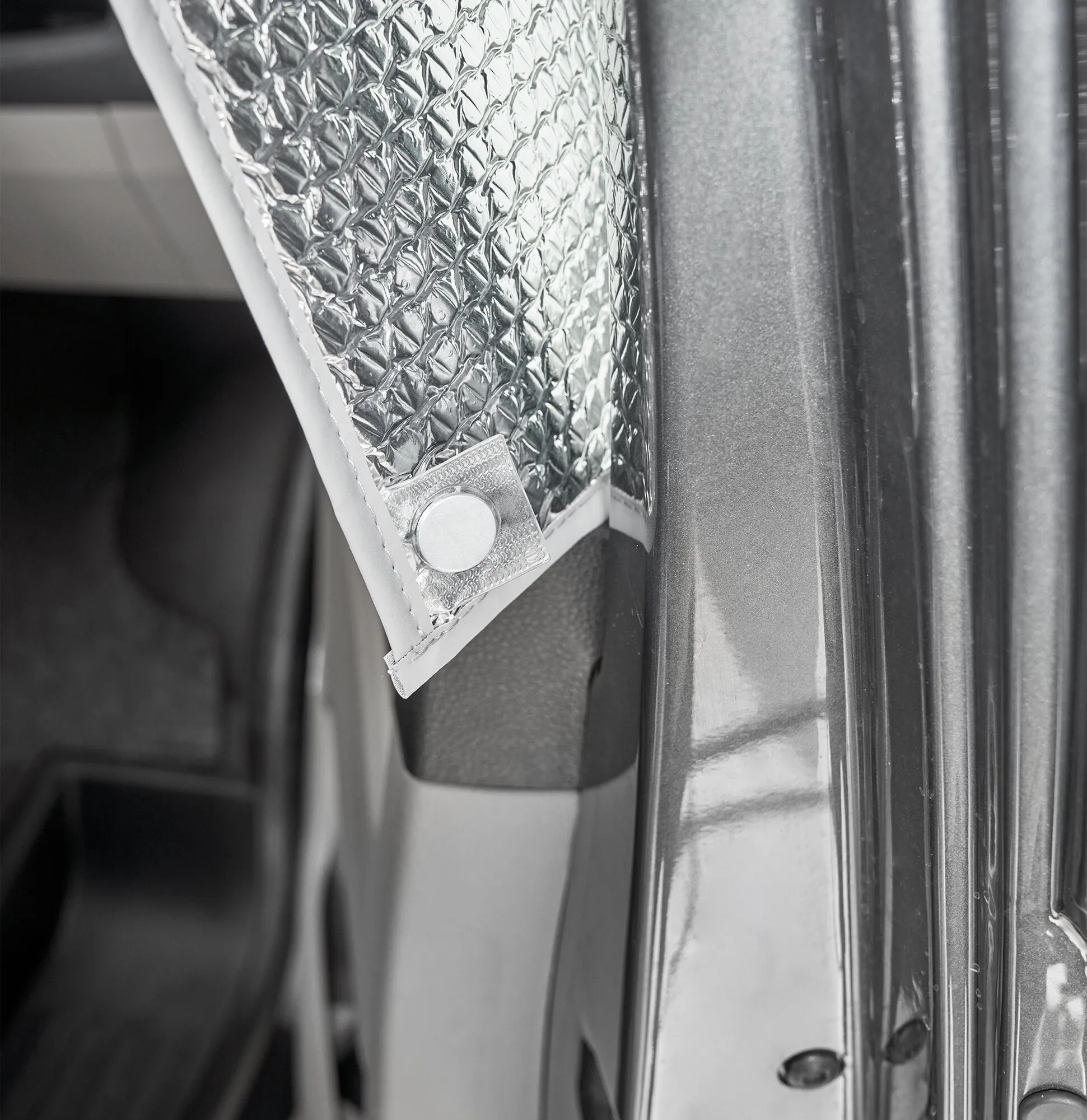 Detailaufnahme einer anthrazitfarbenen Innenisoliermatte Travel mit silberner Diamond-Plate-Oberfläche, geprägtem Muster und Randnaht