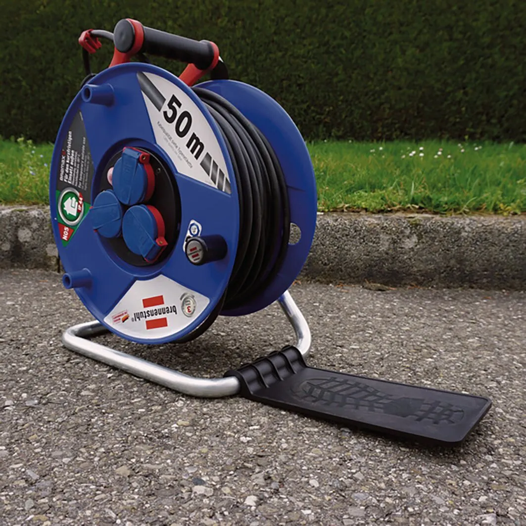 Blaue Kabeltrommel mit 50 Meter schwarzem Kabel auf Metallgestell und ausklappbarem schwarzem Trommeltritt grasbewachsenem Außenbereich