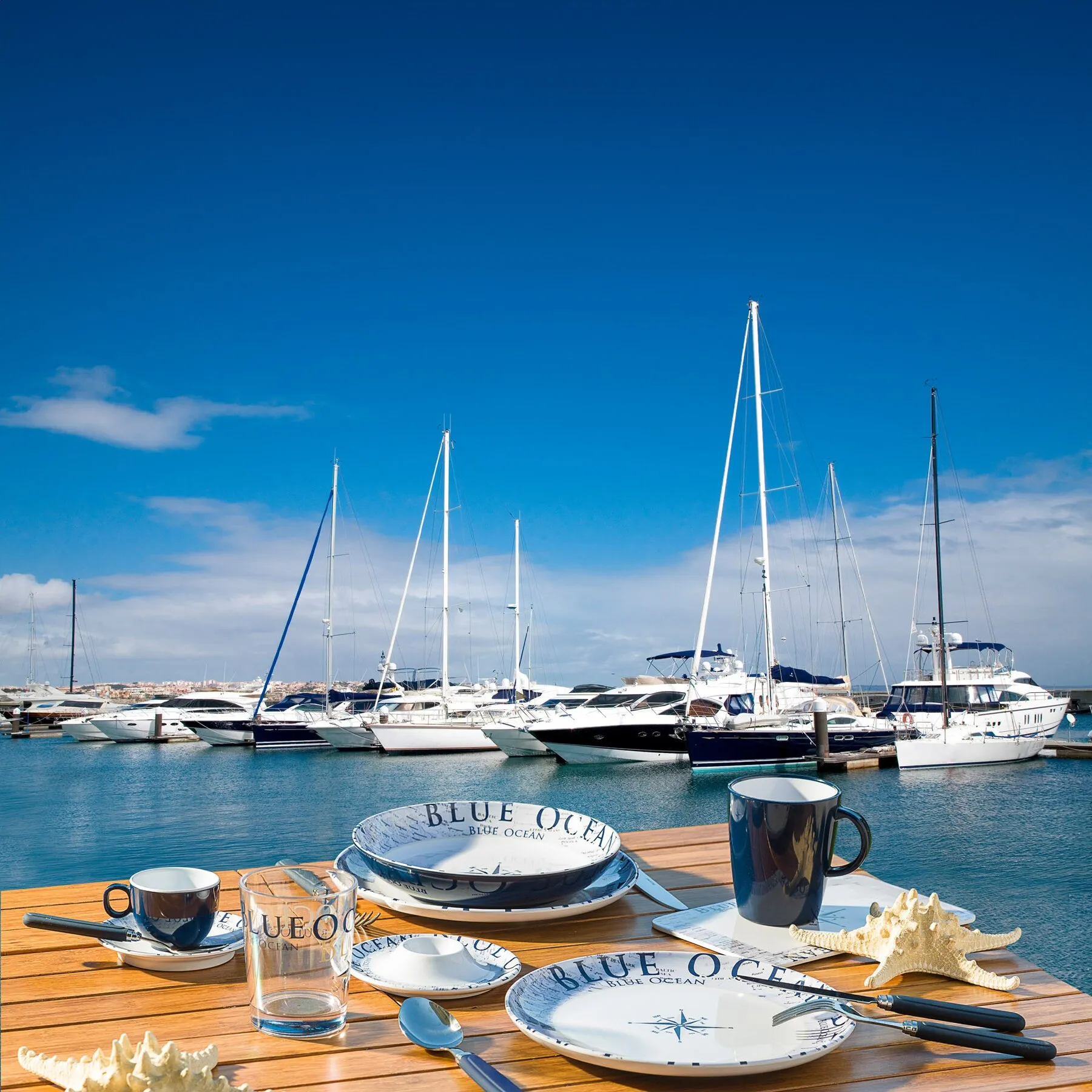 Blue Ocean Geschirrset 37-tlg. mit blau-weißem maritimem Dekor auf einem gedeckten Tisch am Yachthafen