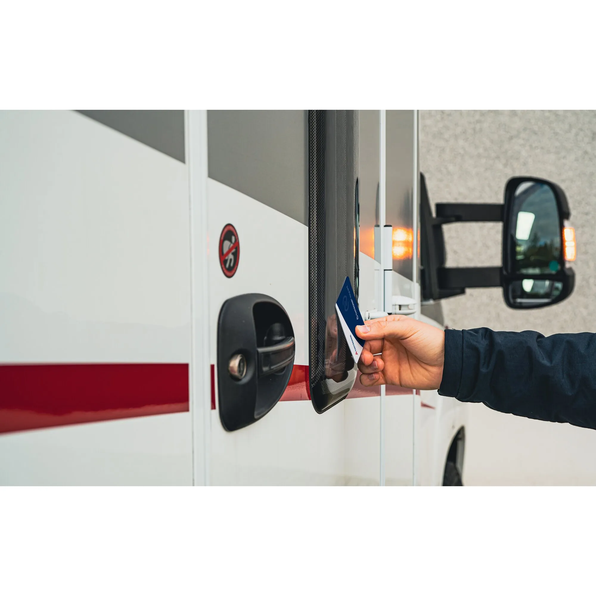 Hand hält eine blaue NFC-Karte an das NFC-Modul einer Fahrzeugtür zur kontaktlosen Authentifizierung