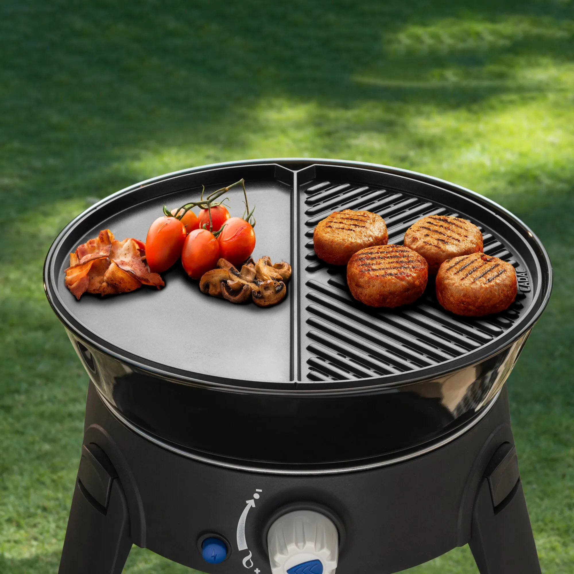 Gasgrill Safari Chef 30 mit geteilter Grillfläche, vier Burgerpatties sowie Tomaten, Pilzen und Speck im Garten