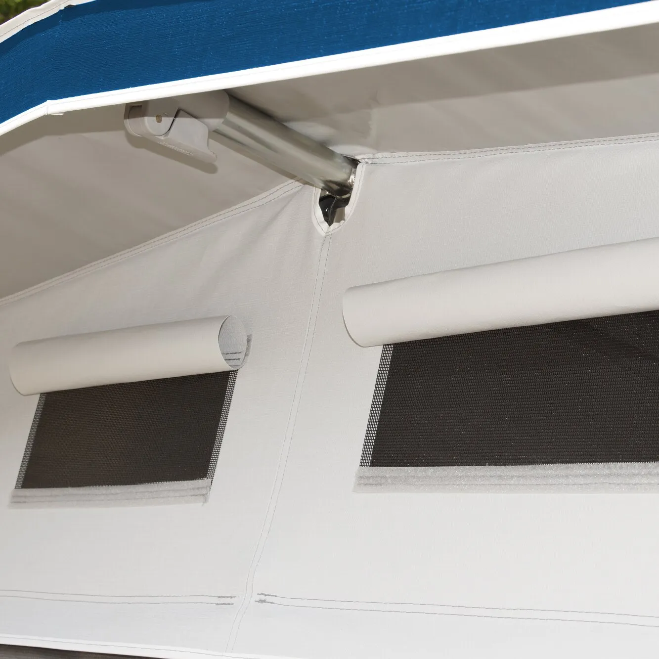Detailaufnahme des weißen Dauervorzelts Feldberg DC mit aufgerollten Fensterabdeckungen, schwarzen Moskitonetzen und Aluminiumgestänge