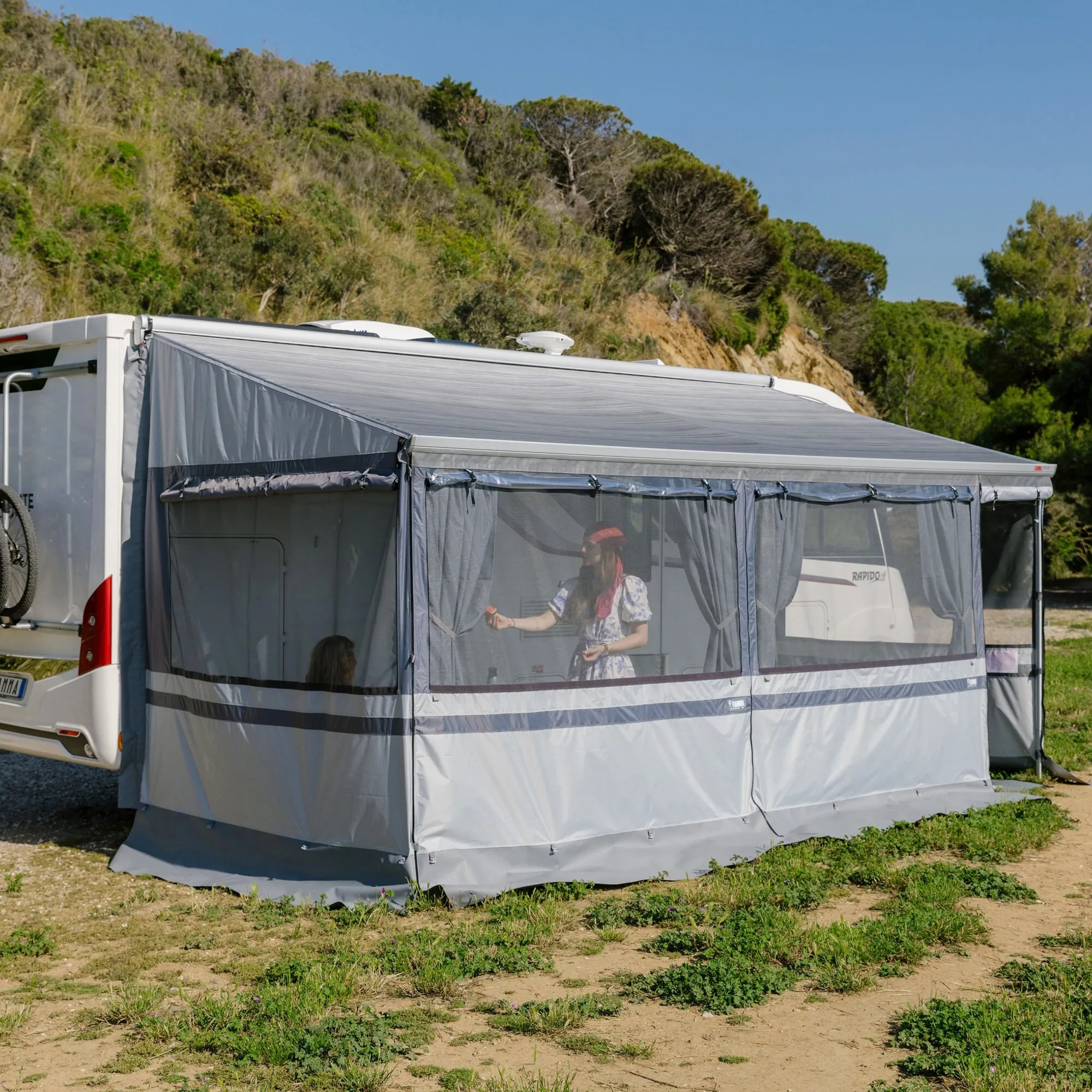 Graues Privacy Room Light F80s Markisenzelt an einem weißen Wohnmobil mit durchsichtigen Fensterflächen im Freiencuntegn