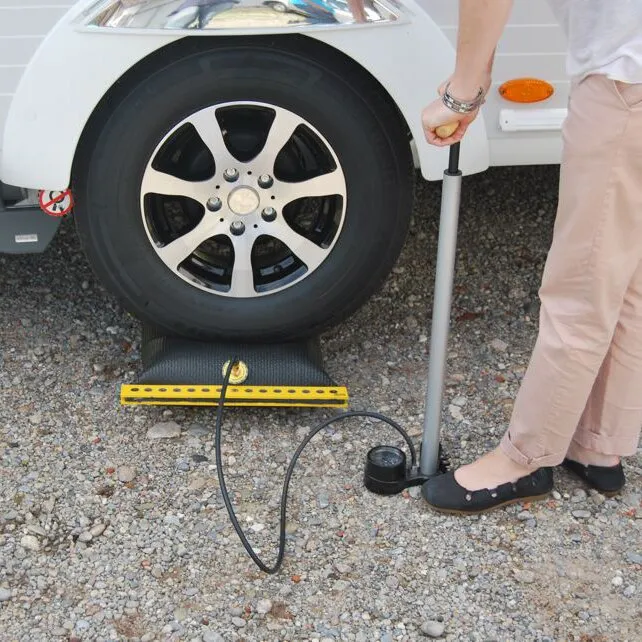 Ausgleichskissen EMUK Air-Lift® 2 unter einem Wohnwagenrad, mit angeschlossener Handpumpe zur Höheneinstellungarsuaq