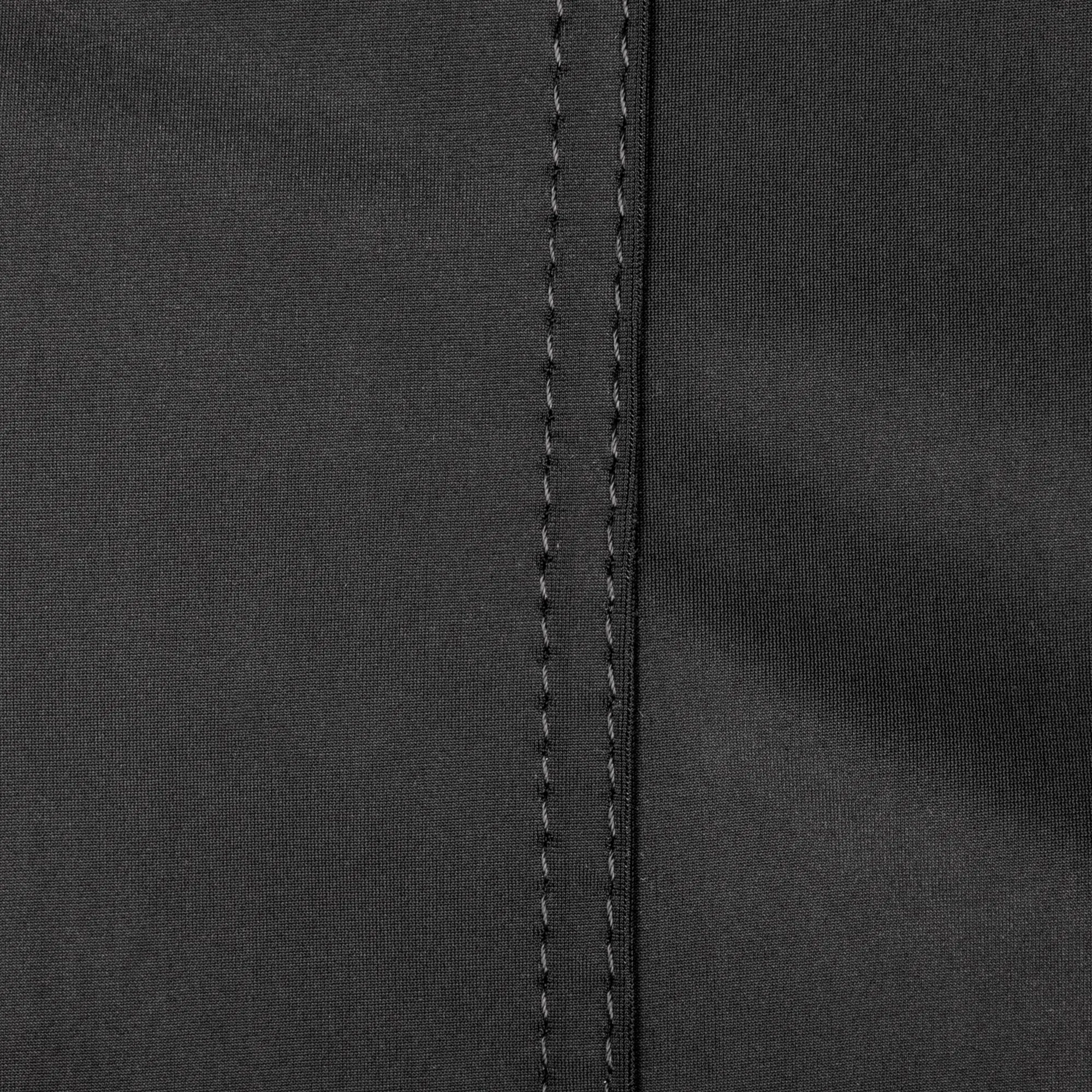 Nahaufnahme eines schwarzen Textilmaterials mit grober Gewebestruktur und zwei parallelen senkrechten Nahtlinien in der Mitte