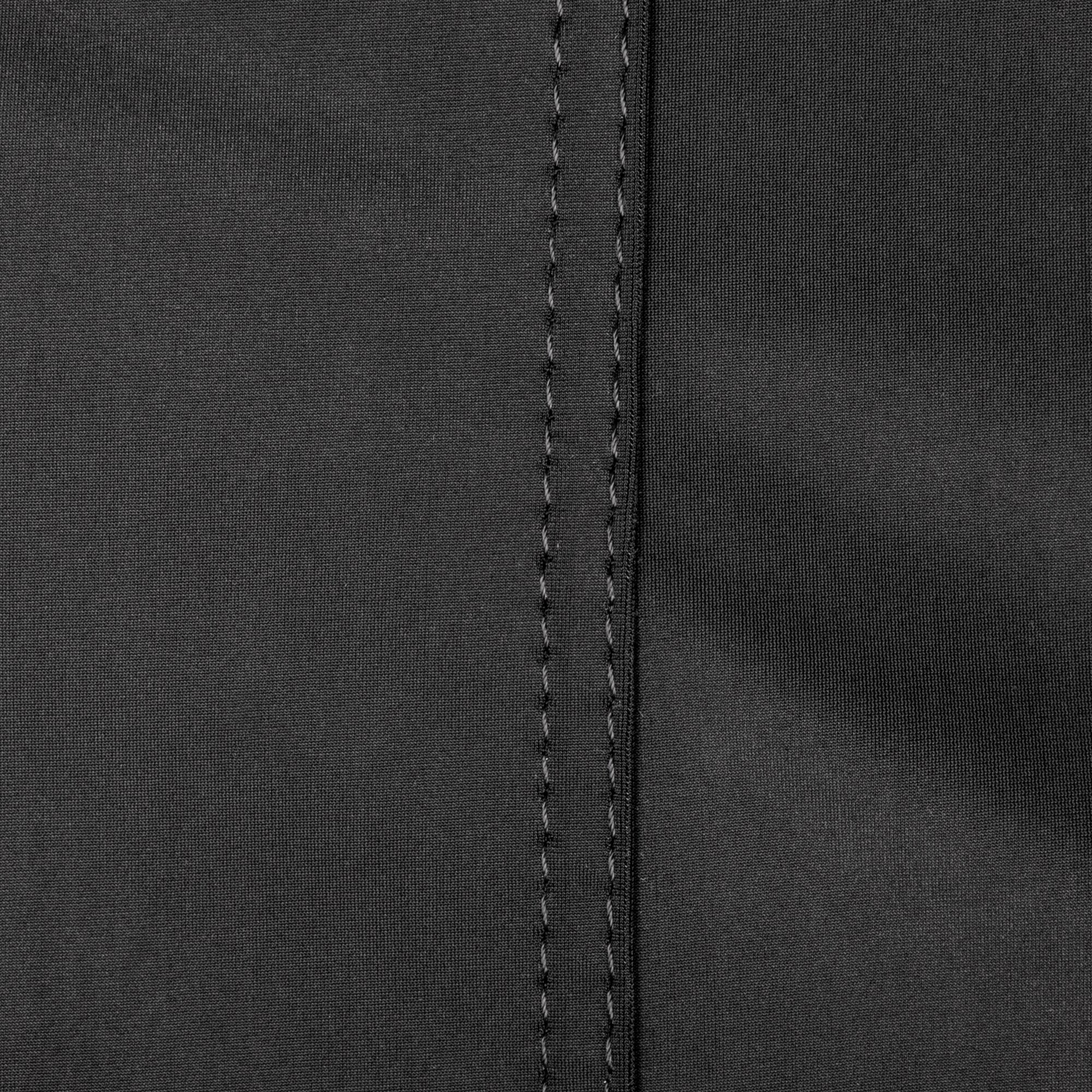 Nahaufnahme eines schwarzen Textilmaterials mit grober Gewebestruktur und zwei parallelen senkrechten Nahtlinien in der Mitte