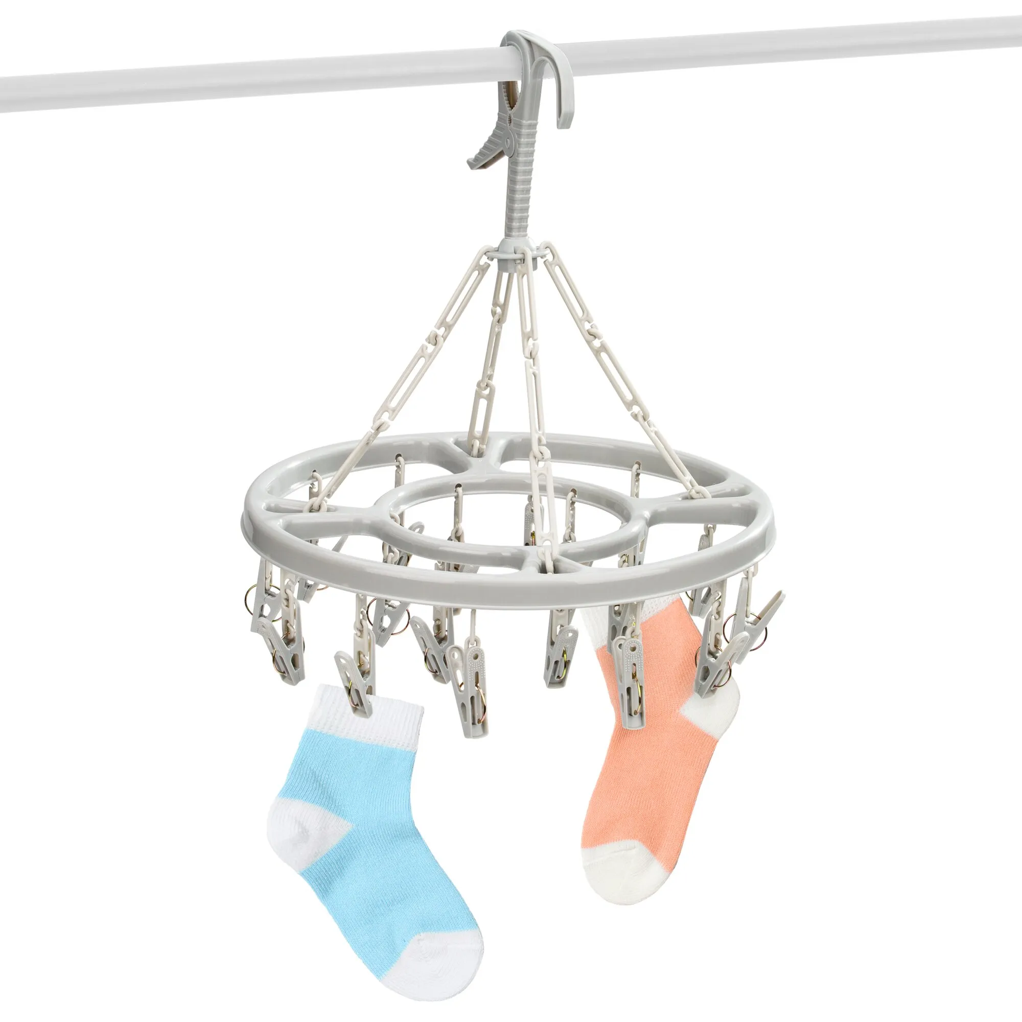 Wäscherad Mini in Weiß mit zahlreichen Wäscheklammern, aufgehängt an einer Stange mit zwei bunten Socken zum Trocknen