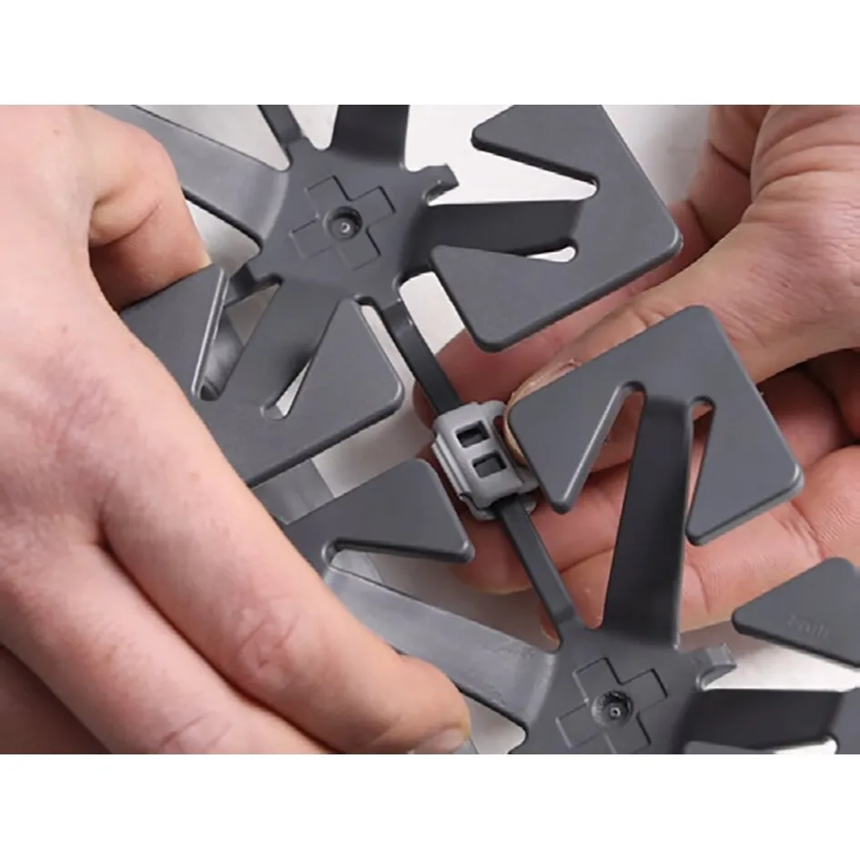 Detailaufnahme eines grauen Froli Schlafsets mit flexiblen Federelementen und Verbindungselementen in Händen ge
haltend
