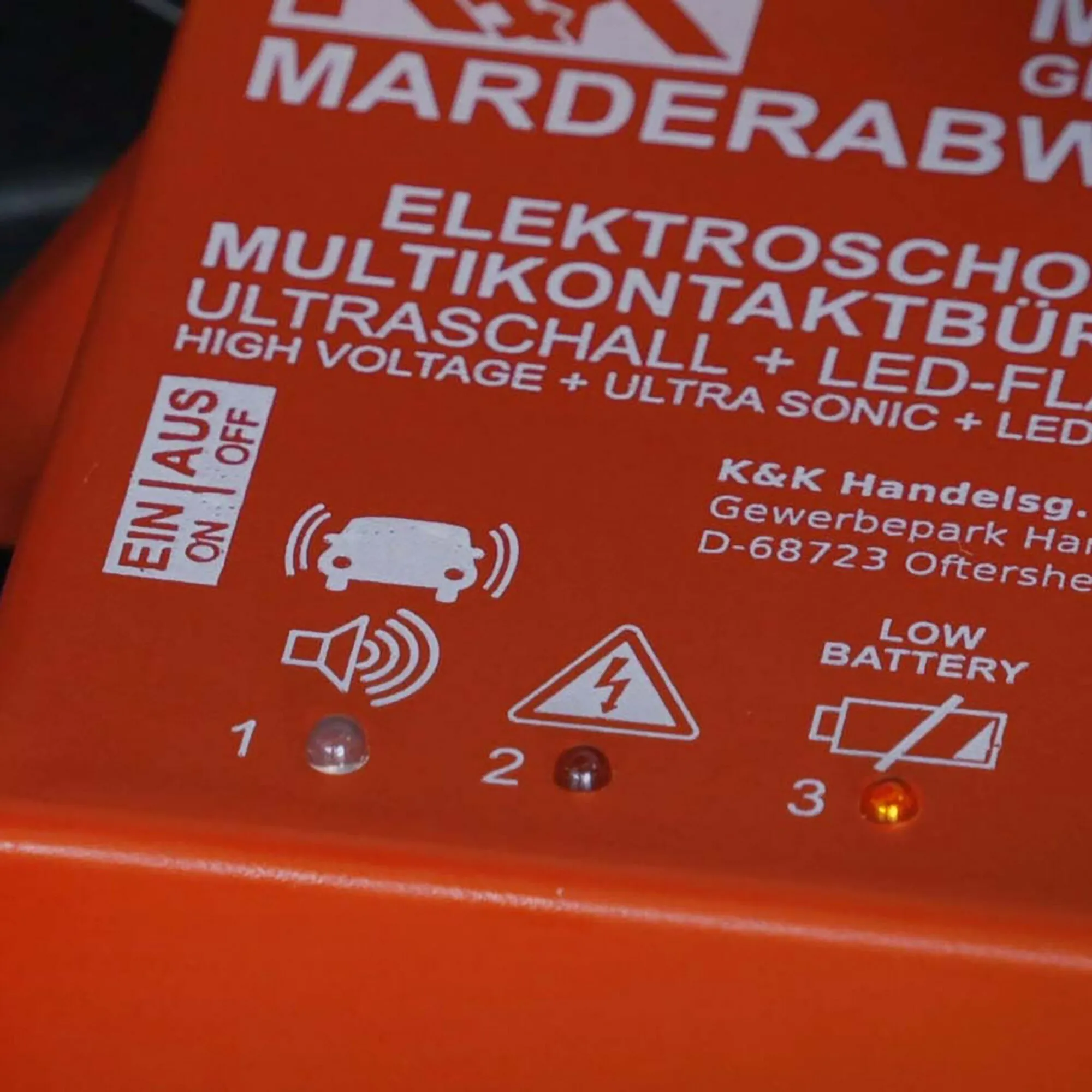 Detailaufnahme des roten Marderabwehrgeräts M9300 mit Warnsymbolen, Kontrollleuchten und Aufdruck für Hochspannung und Ultraschall