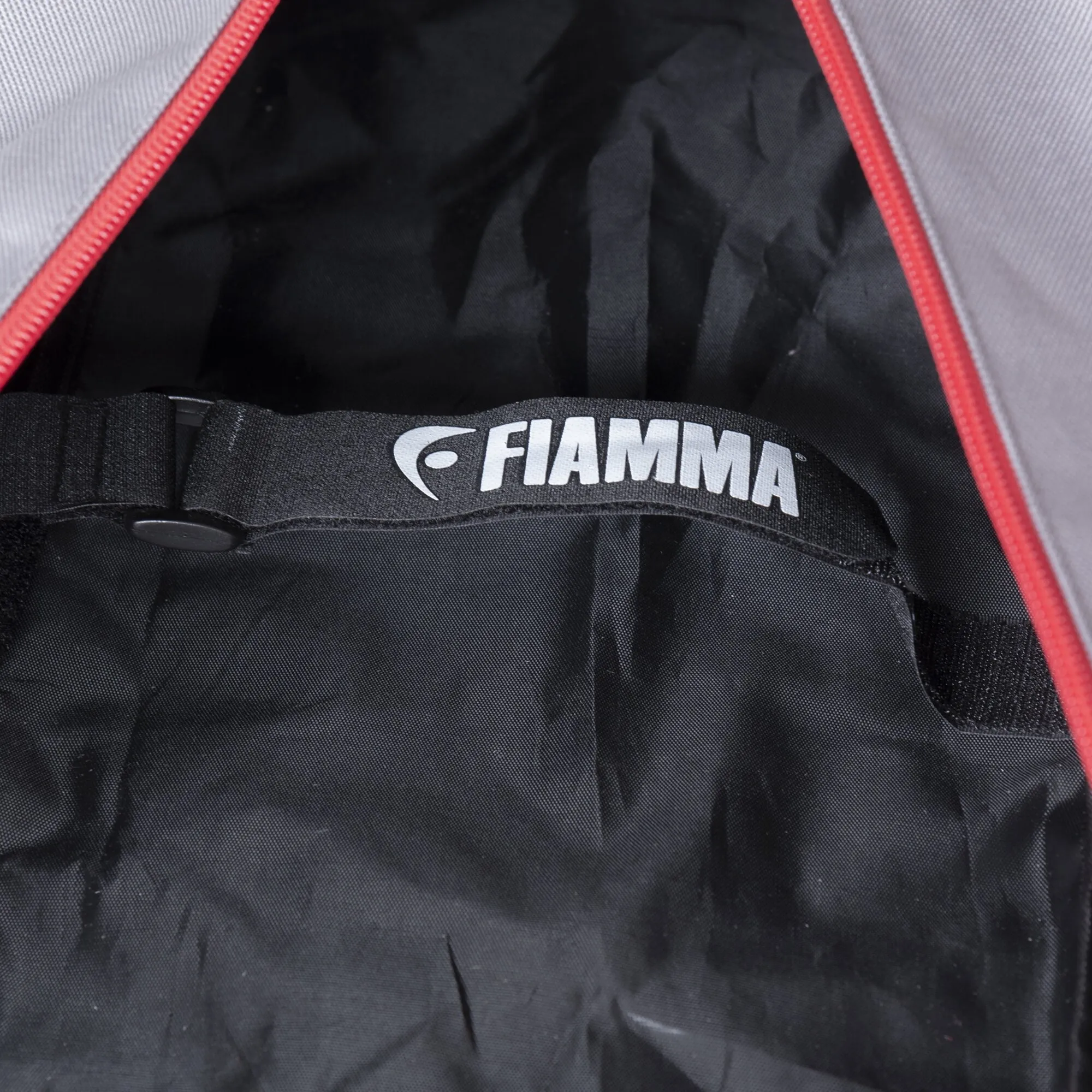 Innenansicht der schwarzen Transporttasche Mega Bag Smart L mit rotem Rand, Tragegurt und weißem Fiamma-Logo