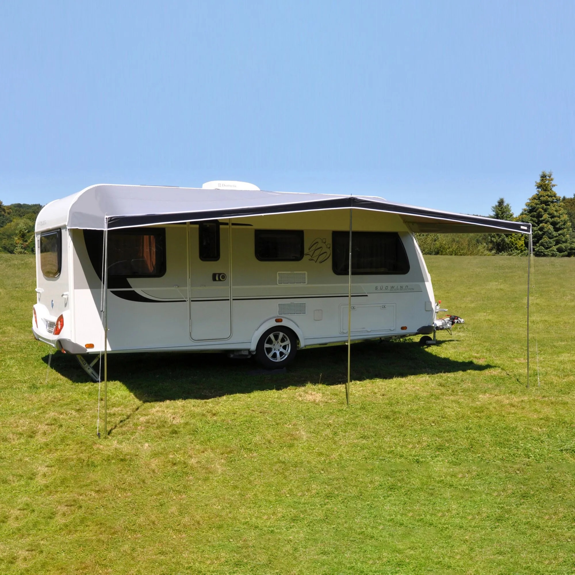 Weißer Wohnwagen mit aufgebautem Sonnendach Kombi in 850 cm Länge auf einer grünen Wiese