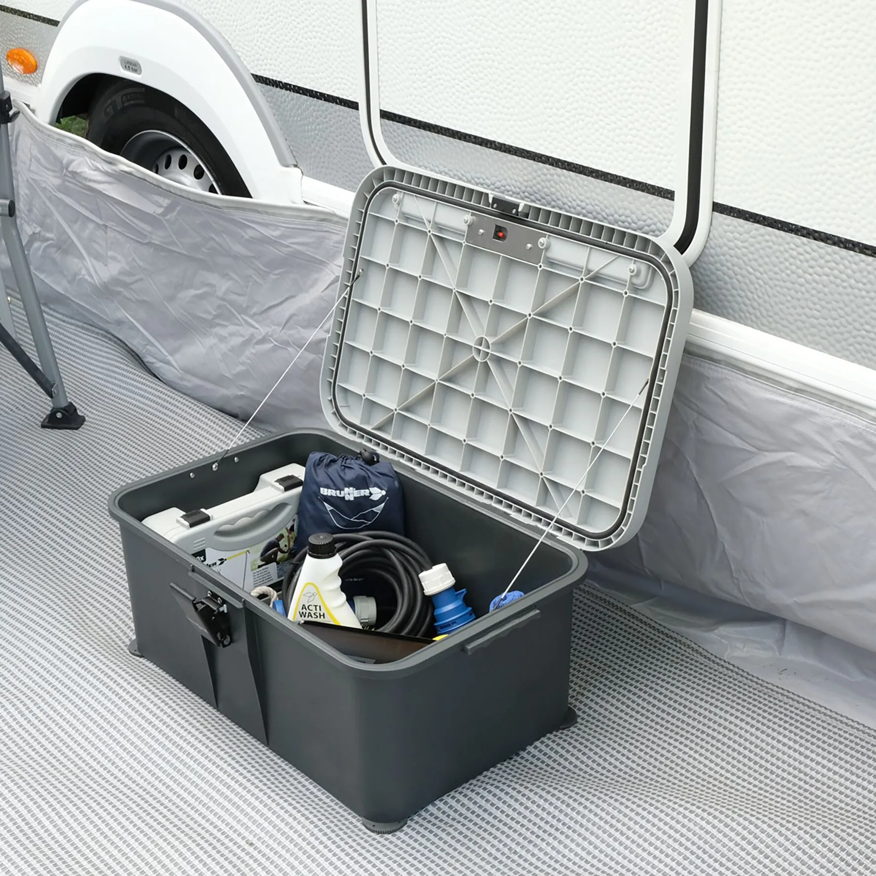 Geöffnete dunkelgraue Trittstufe Boxstep NG als Staubox im Wohnmobil, mit Reinigungsmitteln und Schlauch im Inneren