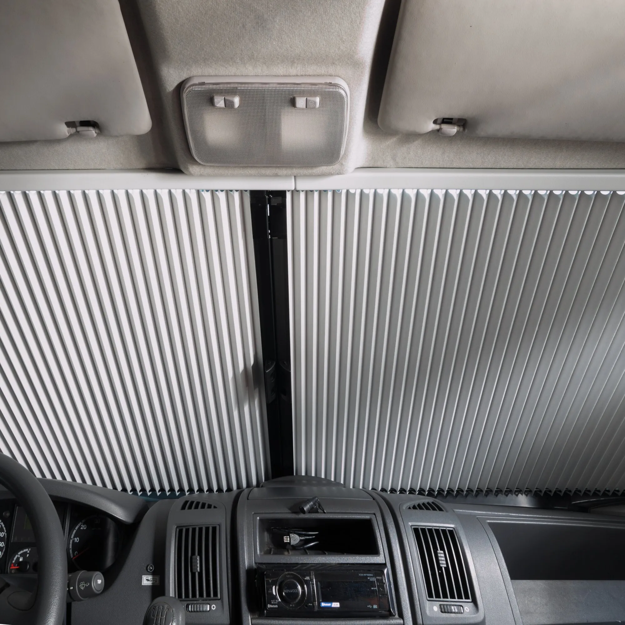 Zusatzblende unten für Remifront IV im Fahrerhaus eines Wohnmobils, montiert unter der Frontscheibenverdunkelung in Weiß-Grau