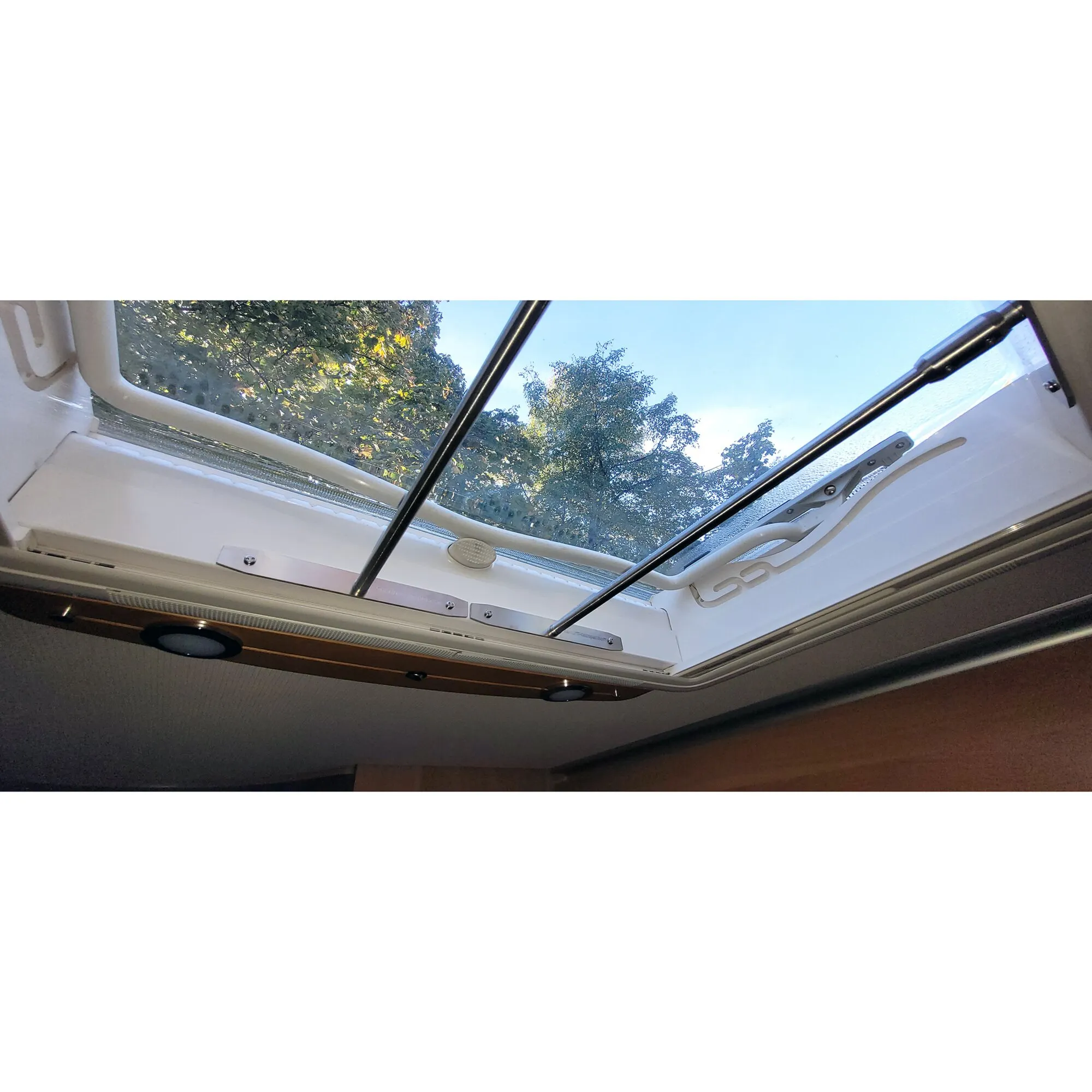 Innenansicht eines geöffneten Dometic Midi Heki im Wohnmobil mit weißem Dachhaubenschutz und schwarzen Haltestreben