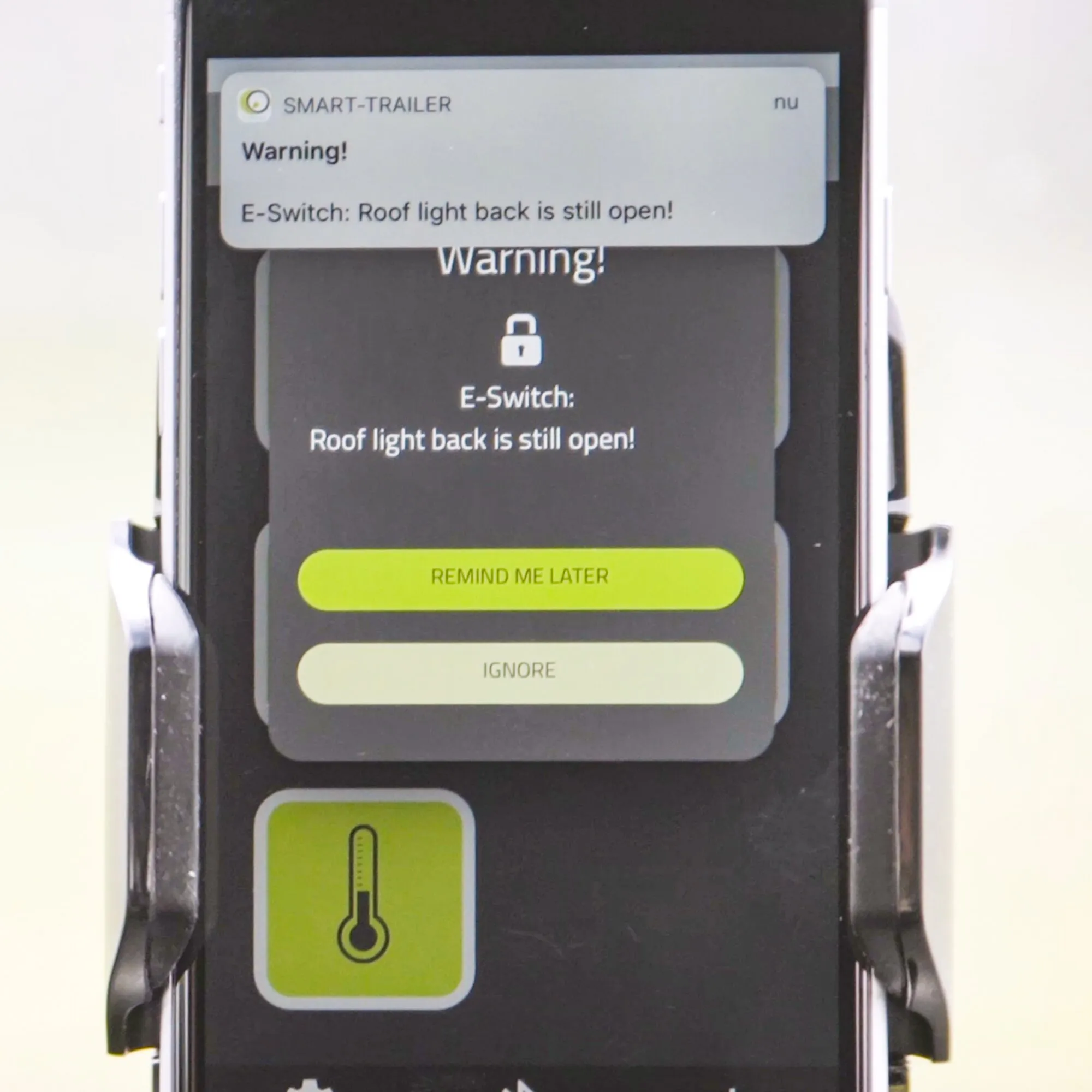 Smart-Trailer-App auf einem Smartphone mit Warnmeldung über ein noch geöffnetes hinteres Dachlicht und zwei Schaltflächen