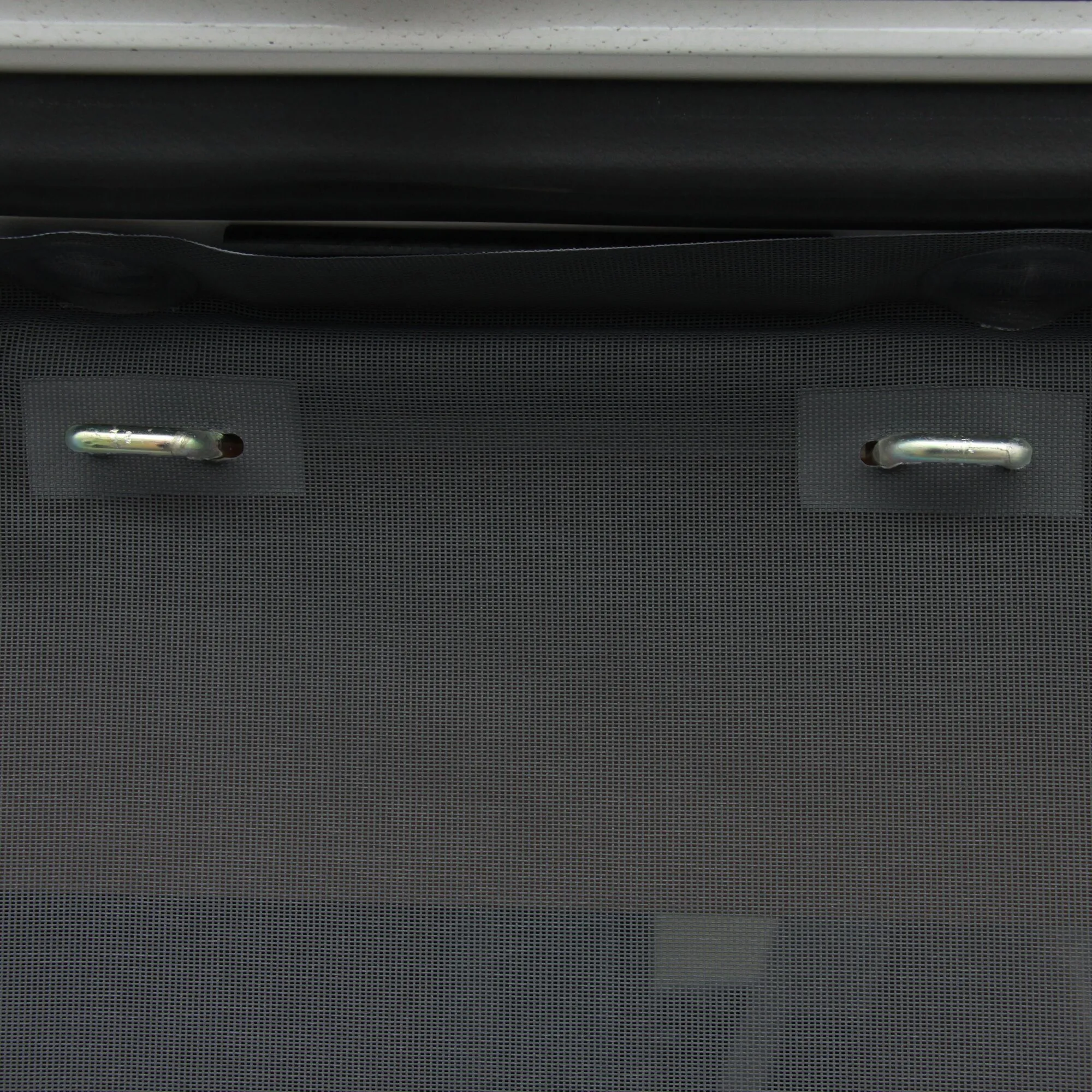 Detailaufnahme des schwarzen Insektenschutzvorhangs für die Hecktür eines Fiat Ducato H2 mit feinmaschigem Netz und zwei Griffen