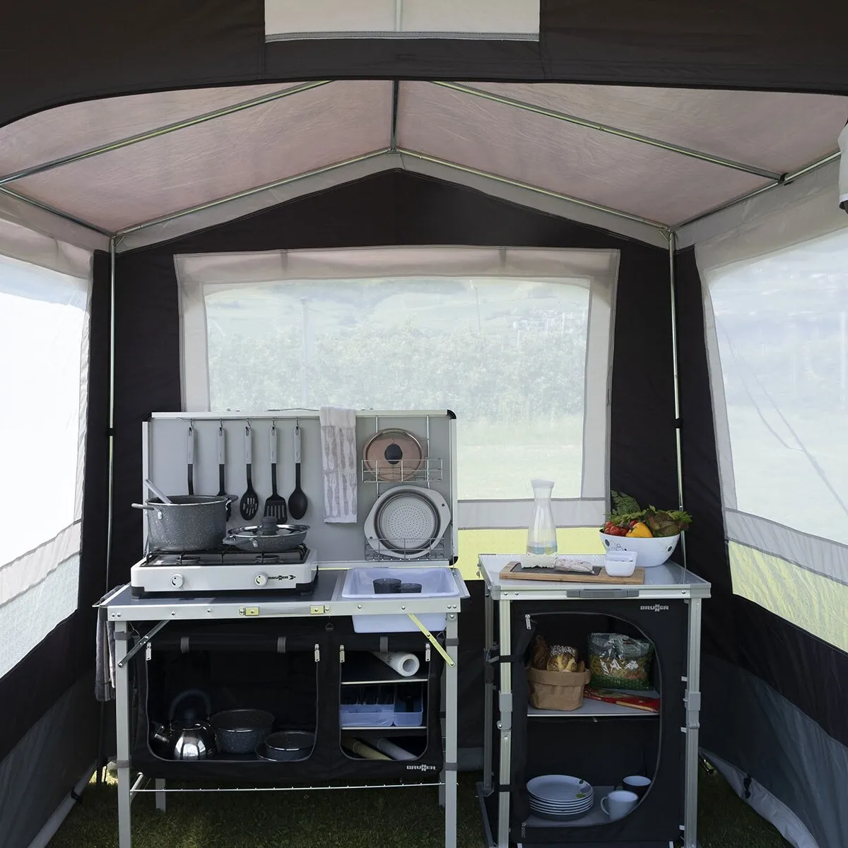 Innenansicht des dunkelgrauen Küchenzelts Gusto II NG mit eingerichteter Campingküche, Kochfeld, Spüle, Stauraum und Fenstern