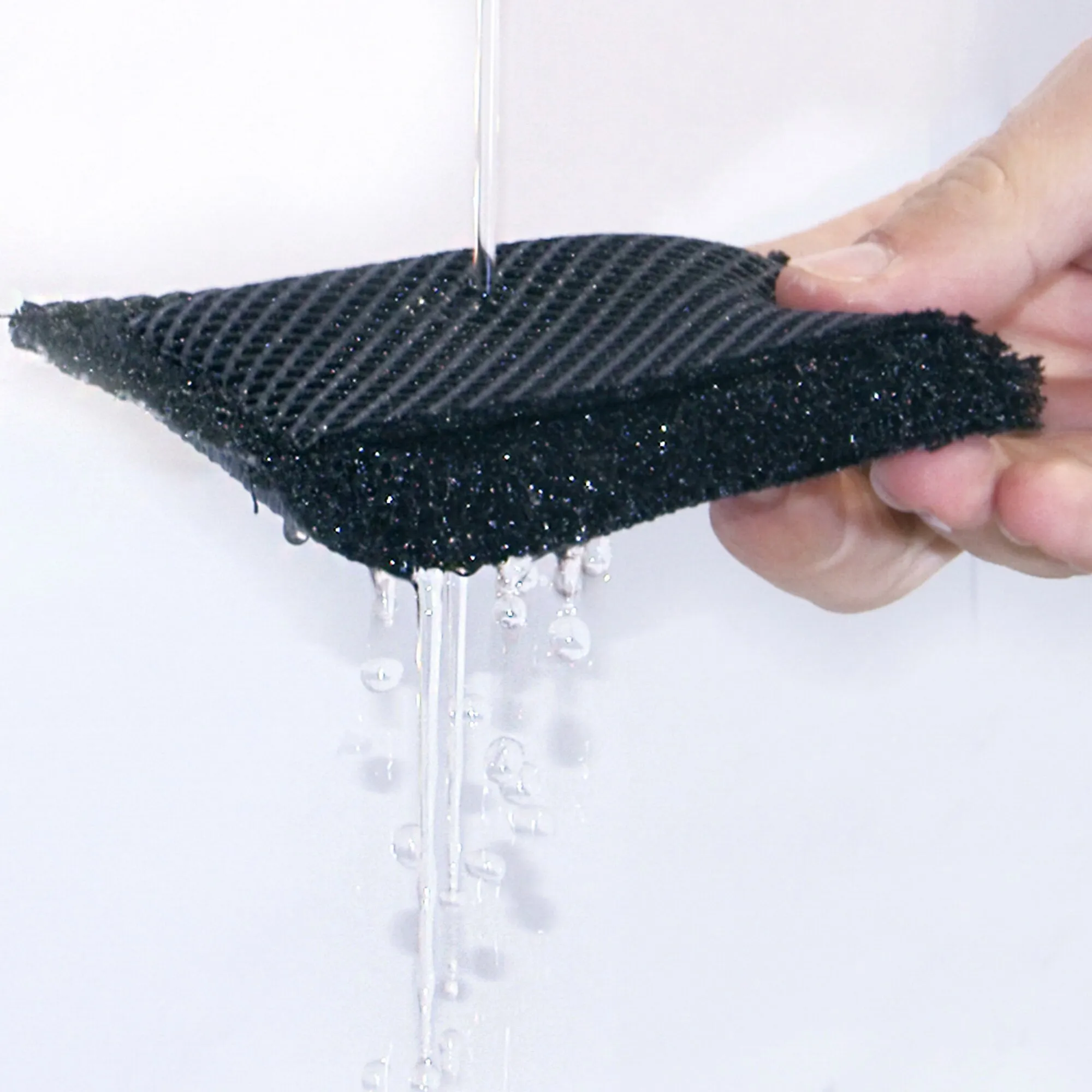 Detailaufnahme der schwarzen Polsterauflage Air-Deluxe, die von Wasser durchströmt wird und Flüssigkeit durch ihre strukturierte Oberfläche ablaufen lässt