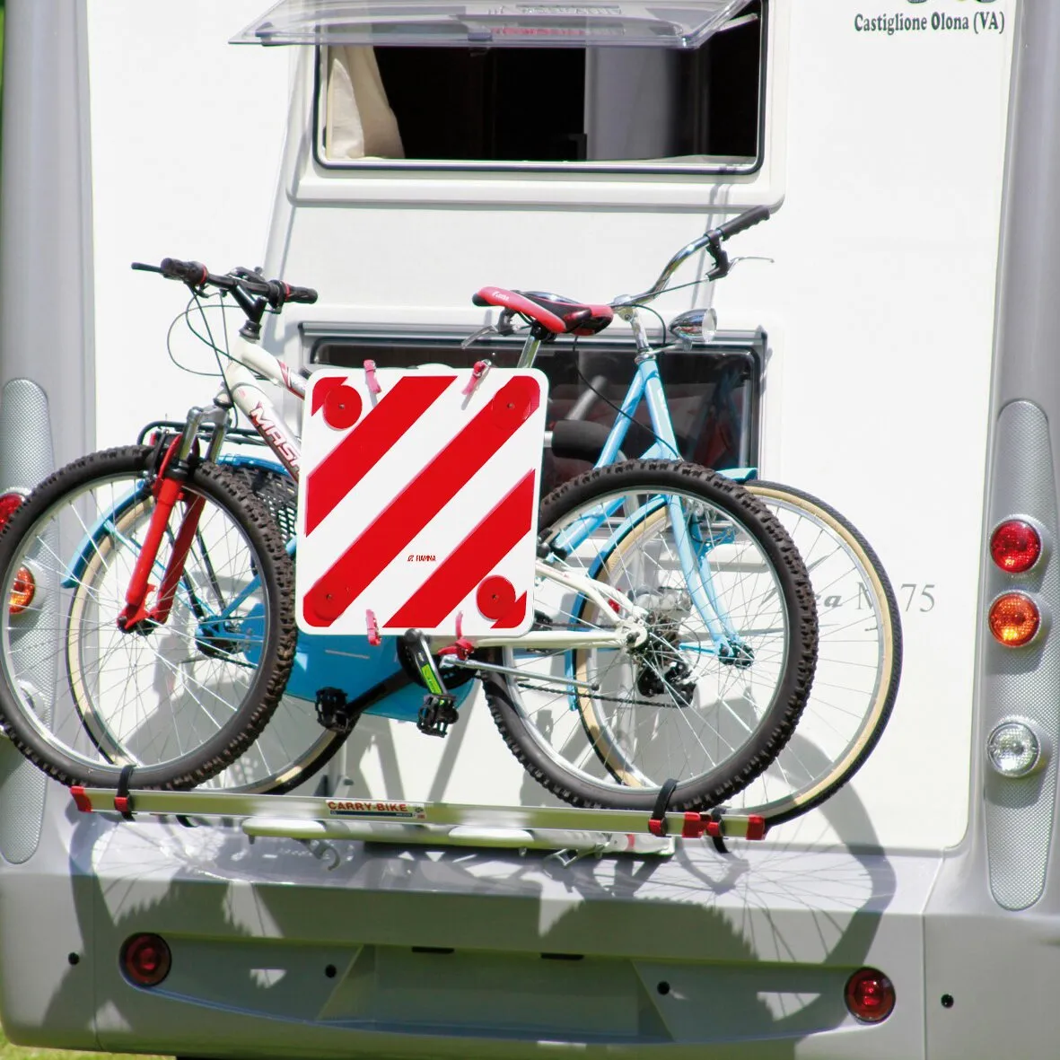 Rot-weiße Warntafel an einem Fahrradträger mit zwei Fahrrädern am Heck eines Wohnmobils