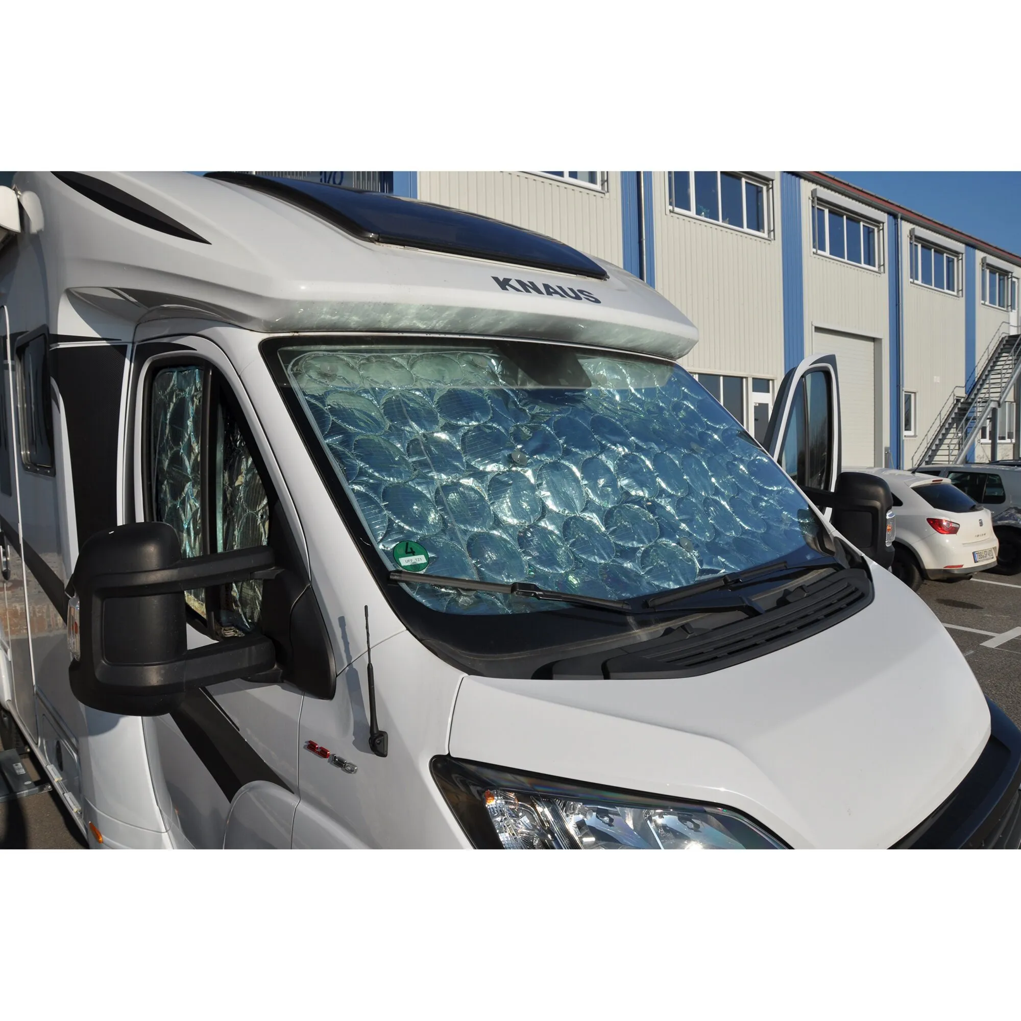 Silberne Thermomatten im Frontbereich eines weißen Knaus-Campingmobils, über Windschutzscheibe und Seitenfenstern angebracht