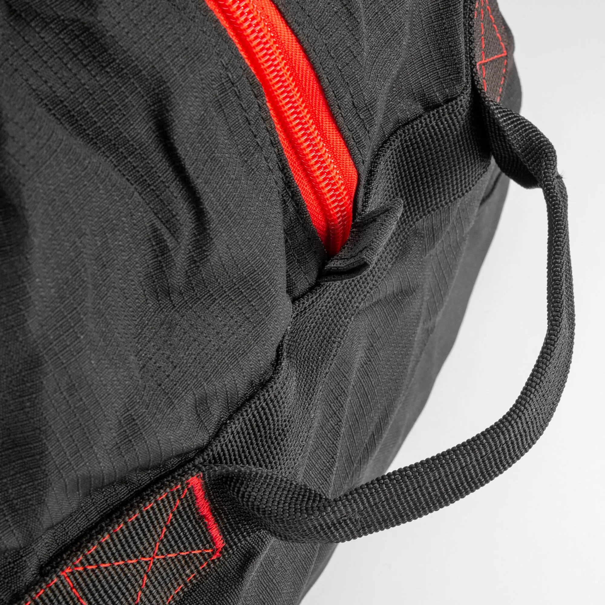 Detailaufnahme der schwarzen Reisetasche Cosmos Duffle 50S mit rotem Reißverschluss, verstärkten Nähten und Tragegriff