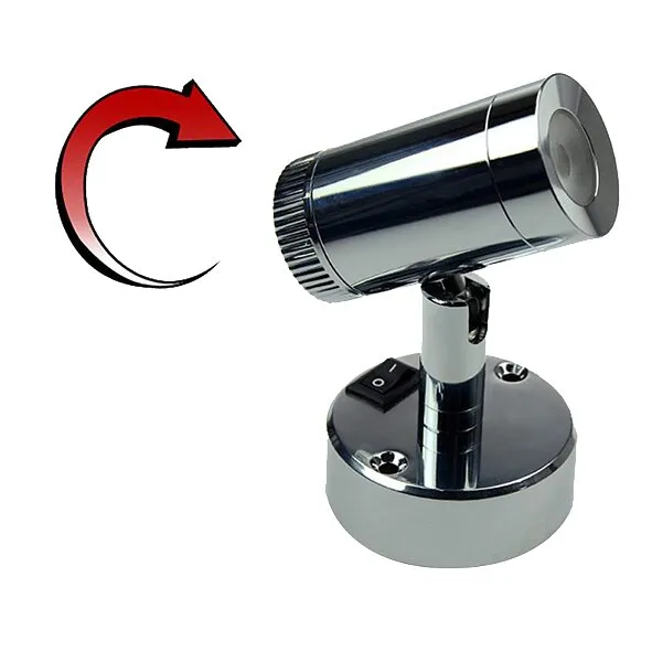 Chromfarbener LED-Miniaufbau-Spot mit zylindrischem Leuchtenkopf, schwenkbarer Halterung, rundem Sockel und Ein-/Ausschalter; roter Drehpfeil sichtbar