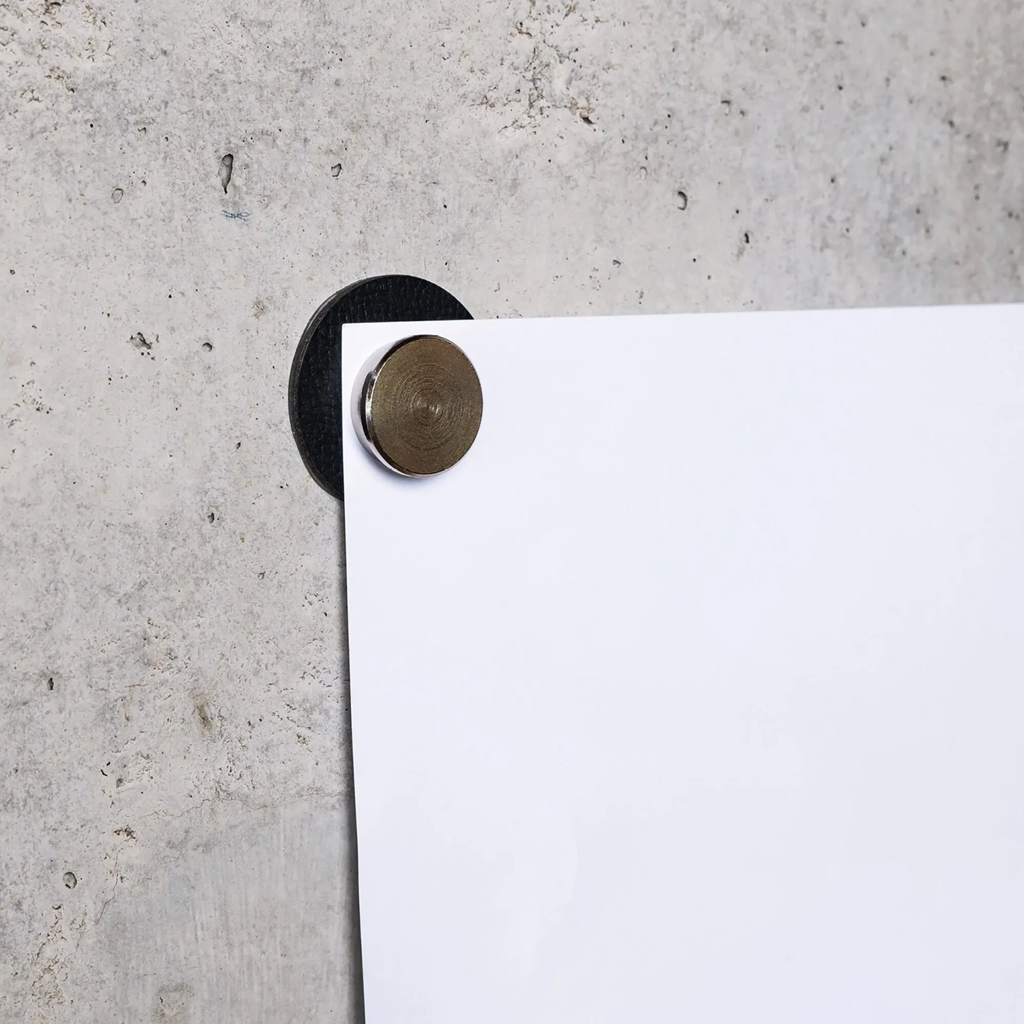 Runder bronzefarbener Magnet-Pin SMART hält ein weißes Blatt Papier auf einer schwarzen Magnettafel fest