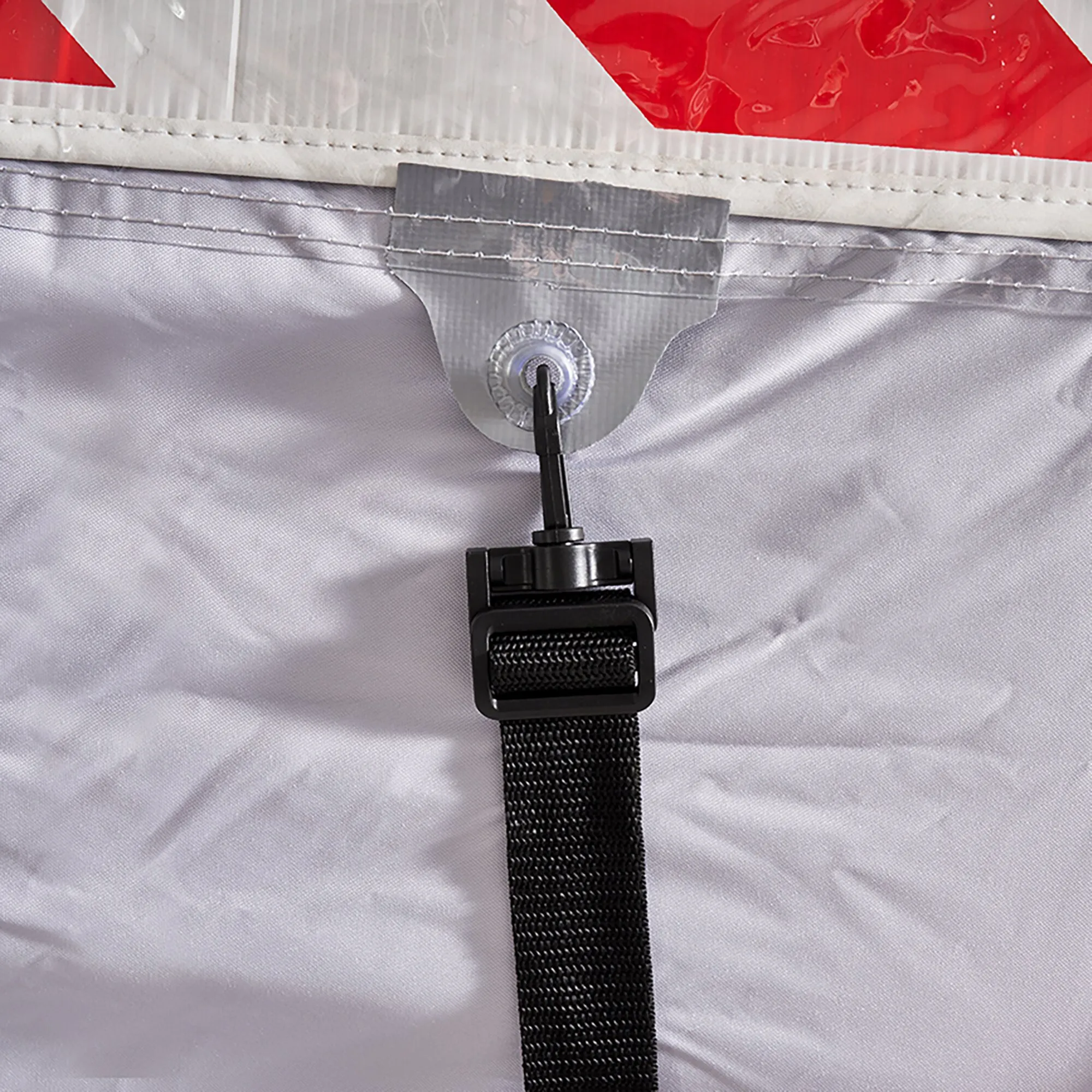 Detailaufnahme der grauen Fahrradschutzhülle Concept Zwoo mit genähten Verstärkungen, Metallöse und schwarzem Befestigungsriemen