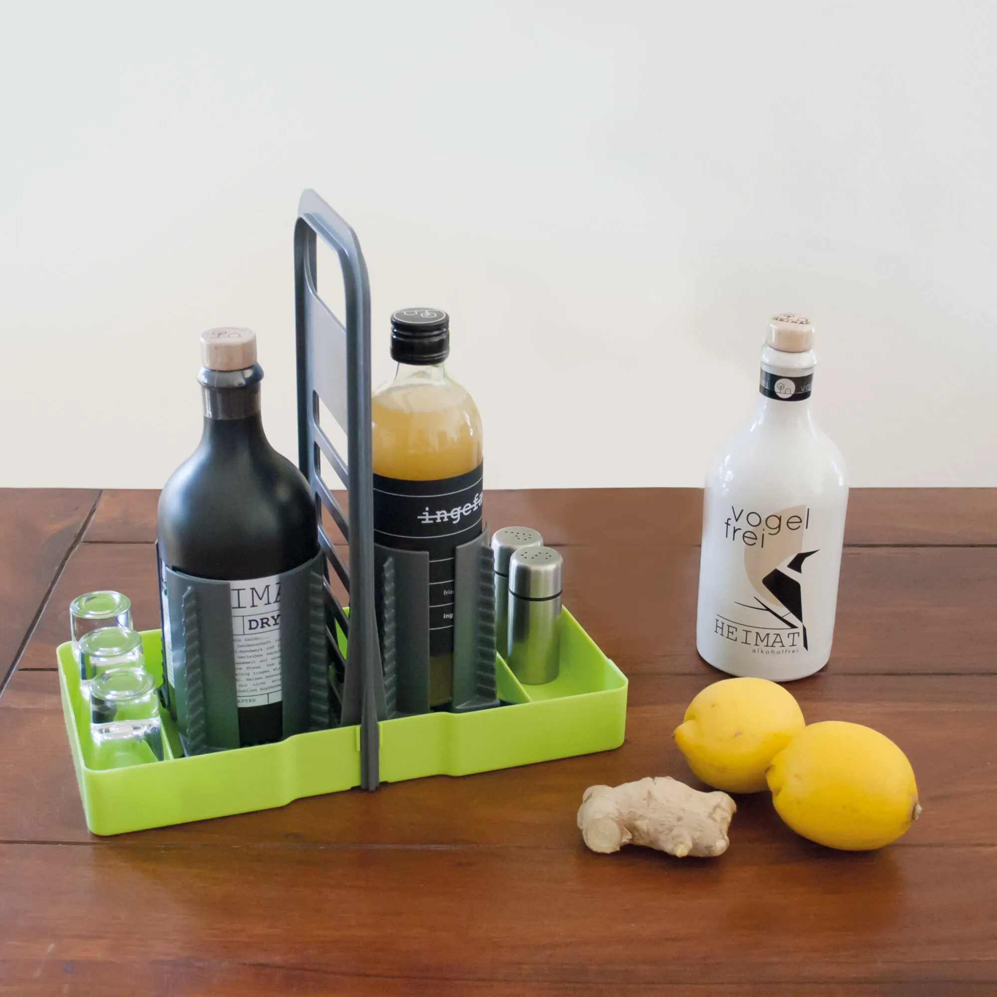 Limettengrüner Flaschenhalter Multi Tray OELE mit mehreren Flaschen, Gläsern und Gewürzstreuern auf einem Holztisch
