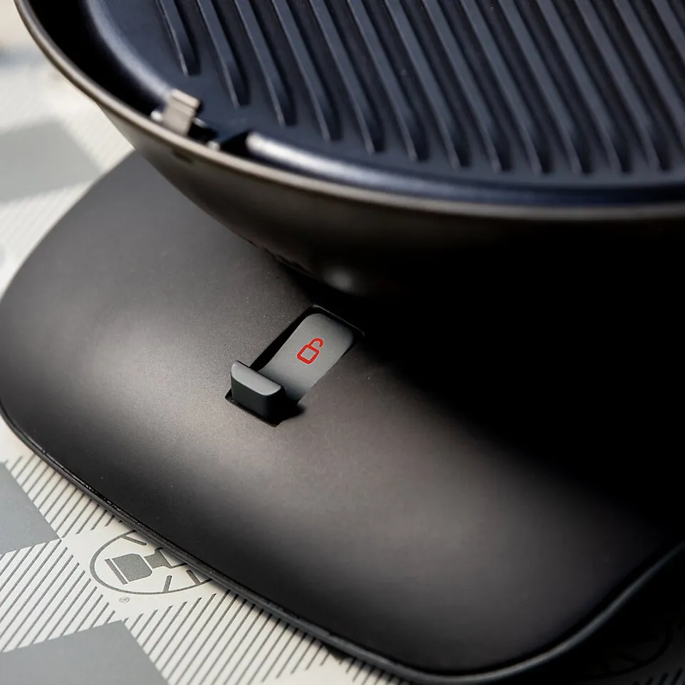 Detailaufnahme des schwarzen Tischgrills 360 Grill CV mit geriffelter Grillplatte und rotem Entriegelungsschalter