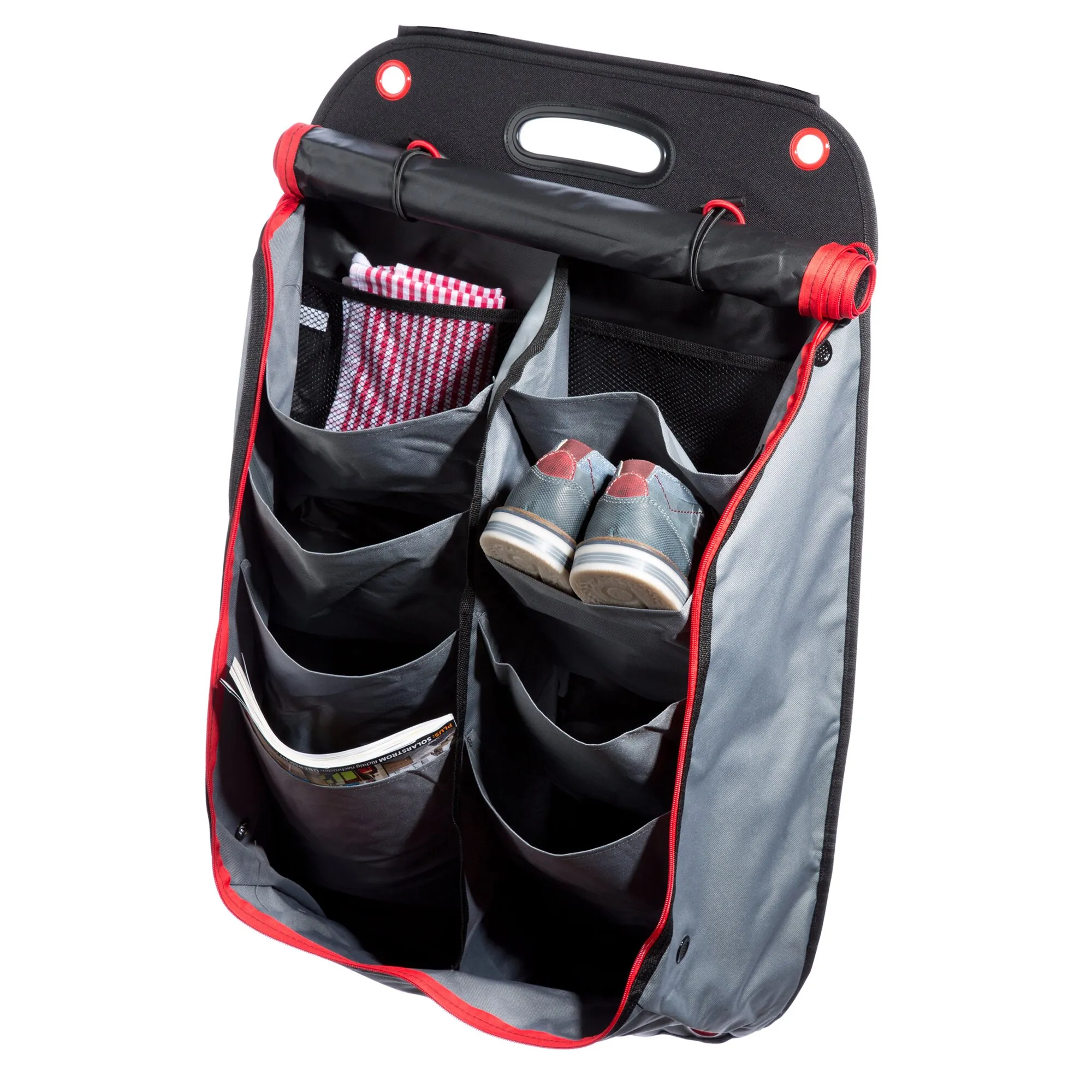 Geöffneter schwarz-grauer Schuh-Organizer mit roten Details, mehreren Fächern, zwei Schuhen, Tuch und Zeitschrift in den Taschen