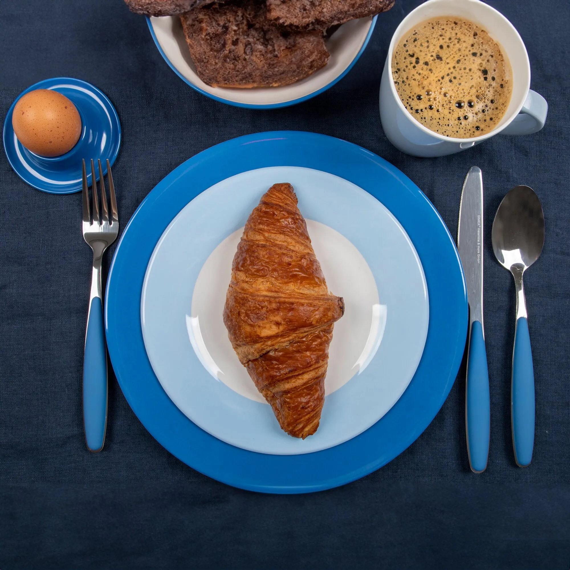 Blaues Geschirrset Colour Line mit Tellern, Schale, Tasse und Unterteller, gedeckt mit Croissant, Brot, Ei und Kaffee