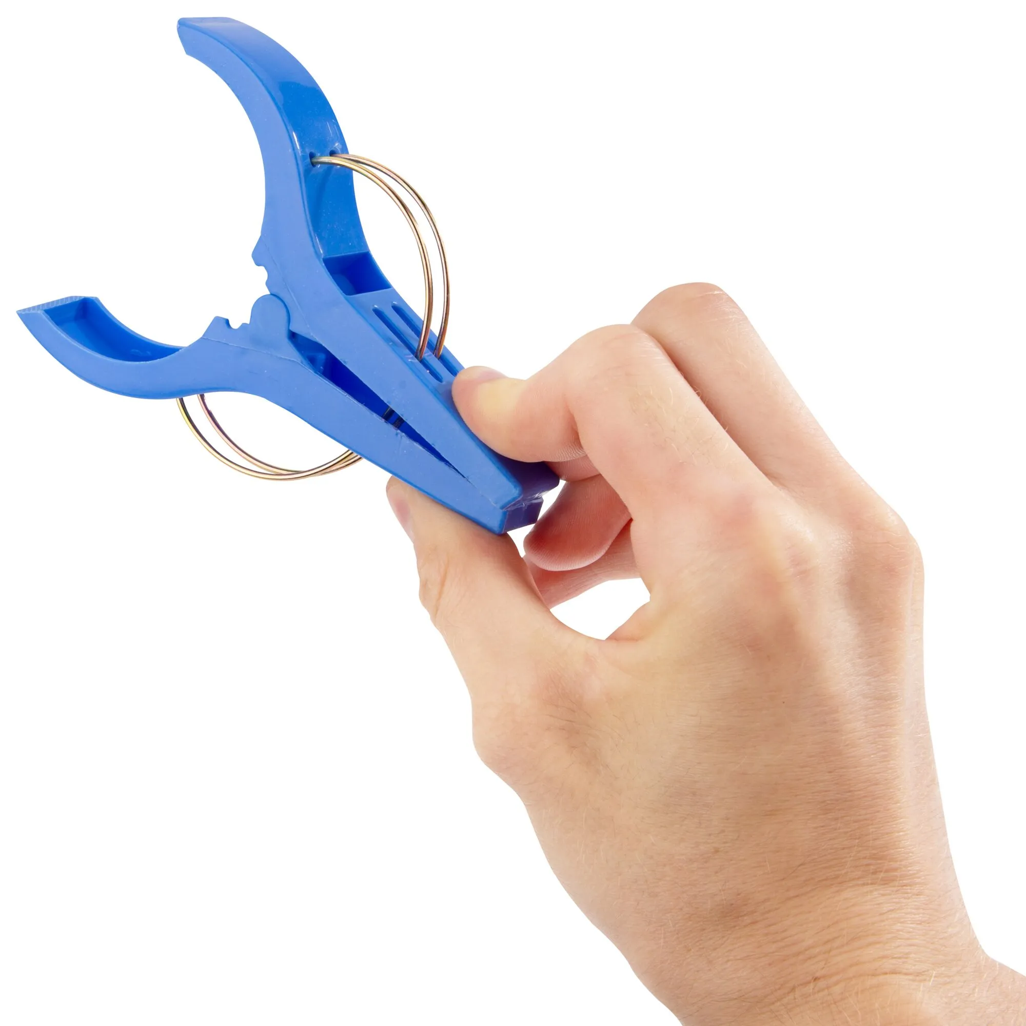 Blaue Strandhandtuchklammer mit Metallring, von einer Hand zusammengedrückt vor weißem Hintergrund