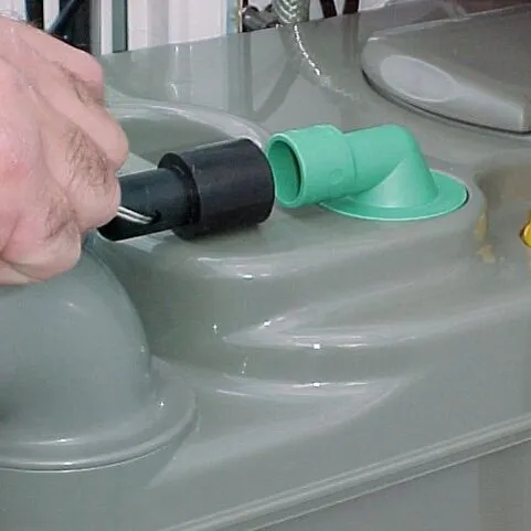 Detailaufnahme einer Hand beim Anschließen der schwarzen elektrischen WC-Entlüftung an den grünen Stutzen einer grauen C200-Kassettentoilette