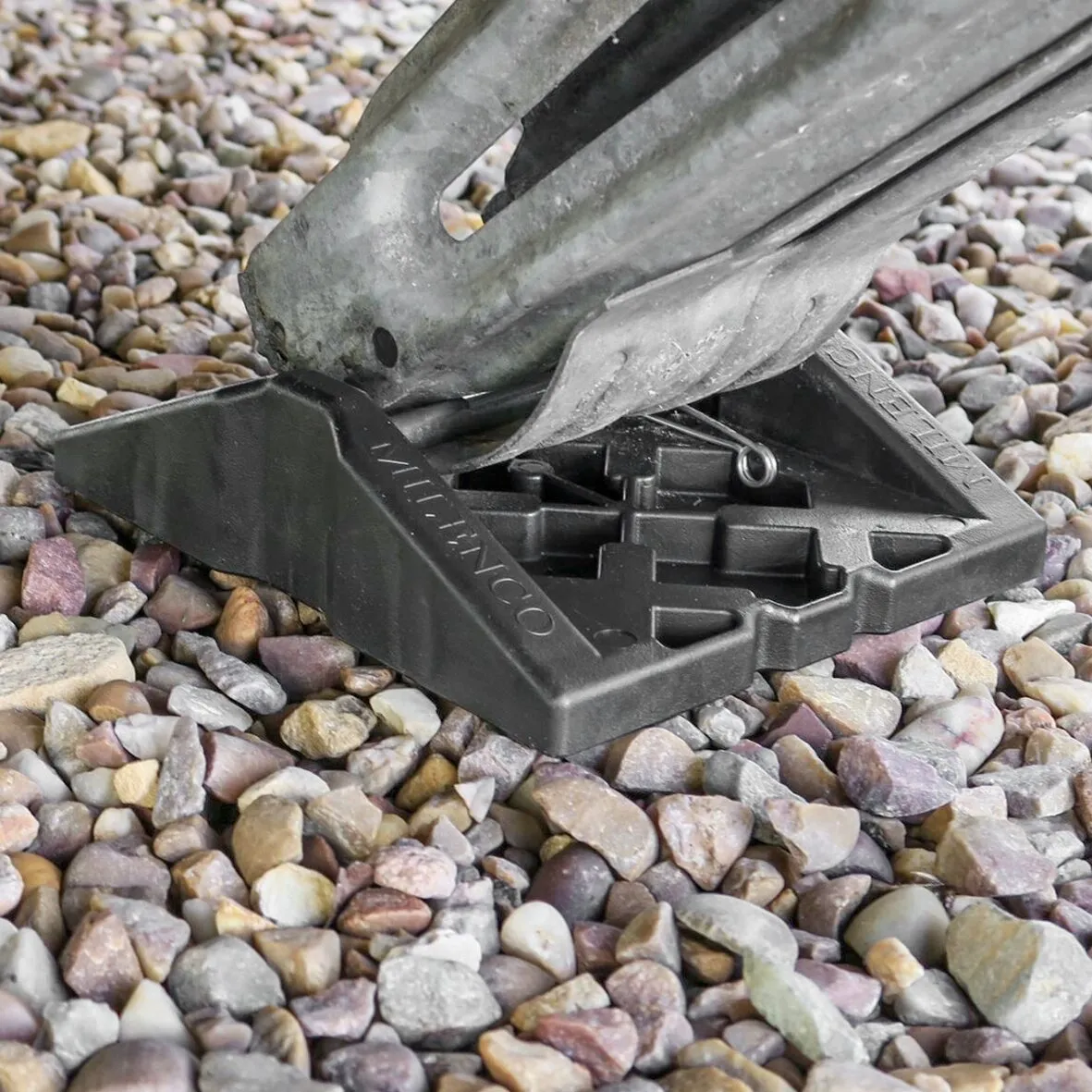 Schwarze Stützplatte Corner Feet mit Metallstütze auf einem Kiesbett, Detailansicht der rutschhemmenden Unterseite