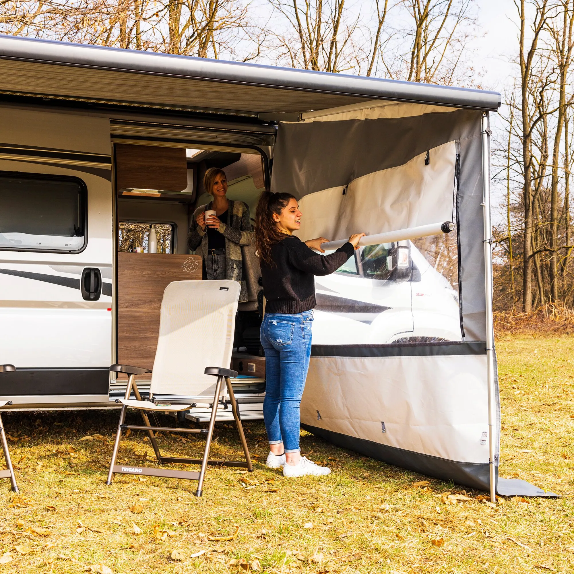 Rechte Seitenwand Side W Pro Shade F45/F80 in Grau an einem Wohnmobil, während eine Frau sie ausrollt und befestigt