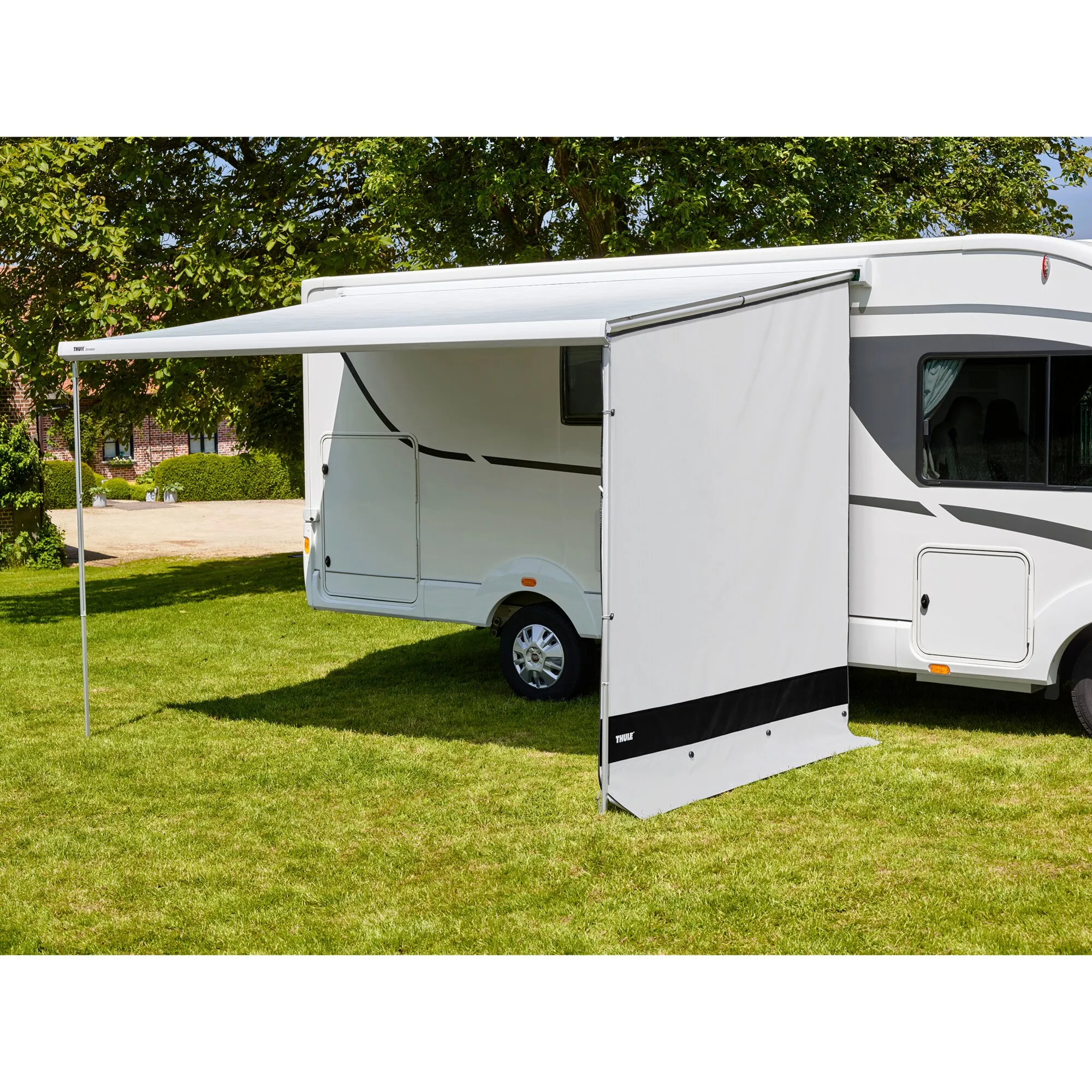 Thule View Blocker Front 2,80 m als weiße Seitenwand an einer Wohnwagenmarkise befestigt grasendem Stellplatz