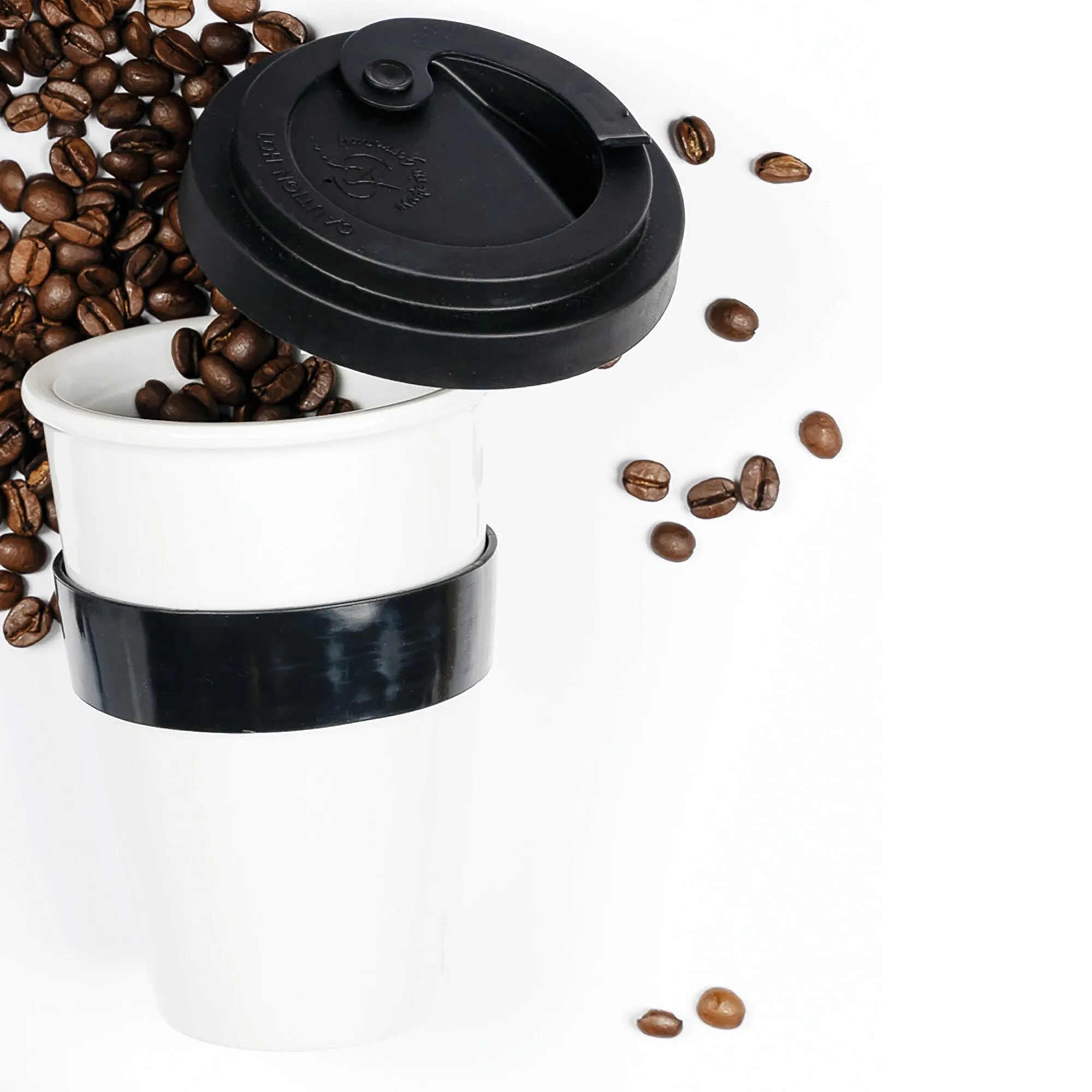 Weißer Porzellan-Kaffeebecher als To-go-Cup mit schwarzem Deckel und schwarzer Manschette, umgeben von Kaffeebohnen