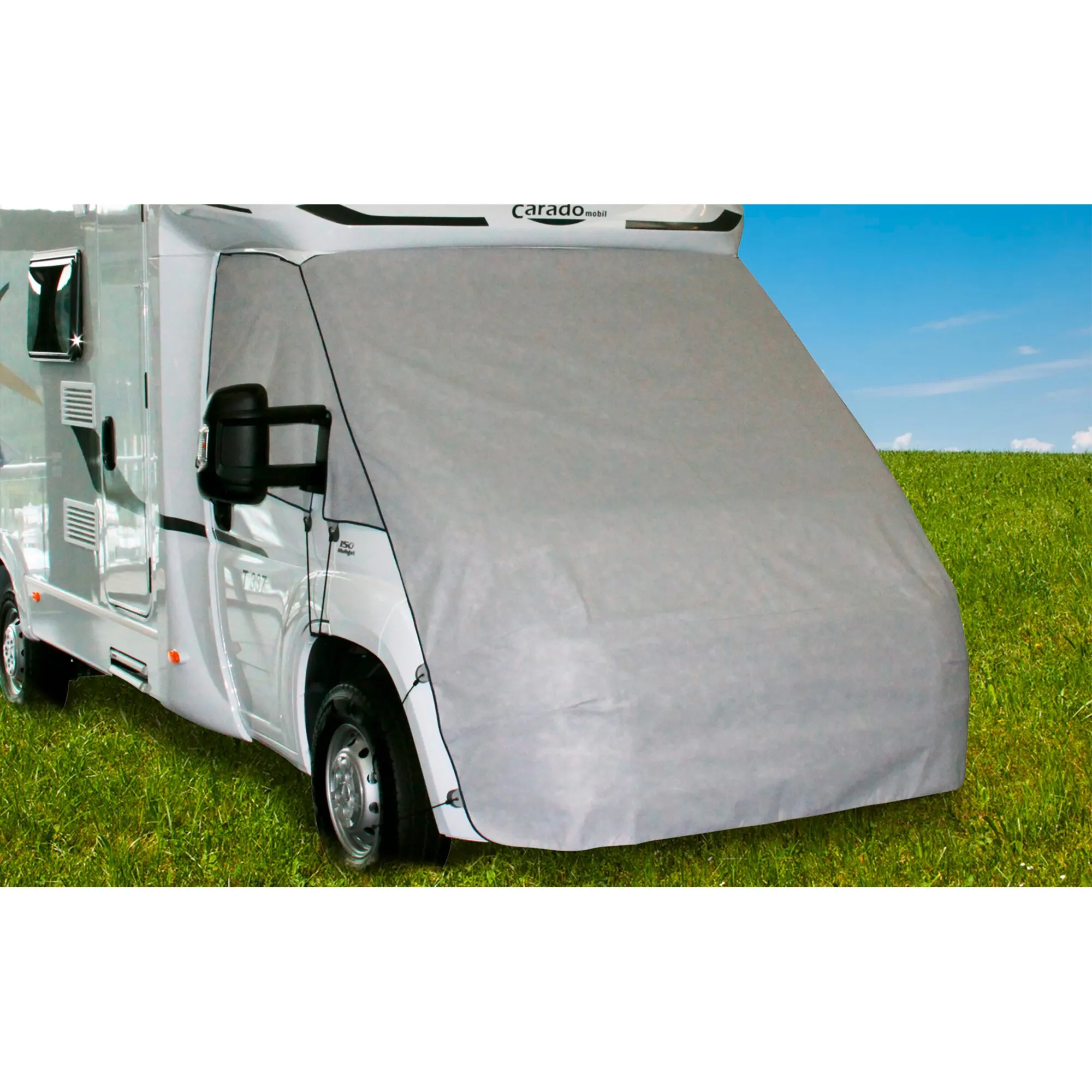 Graue Reisemobil-Frontschutzplane Supra bedeckt die Front eines weißen Wohnmobils auf einer Wiese