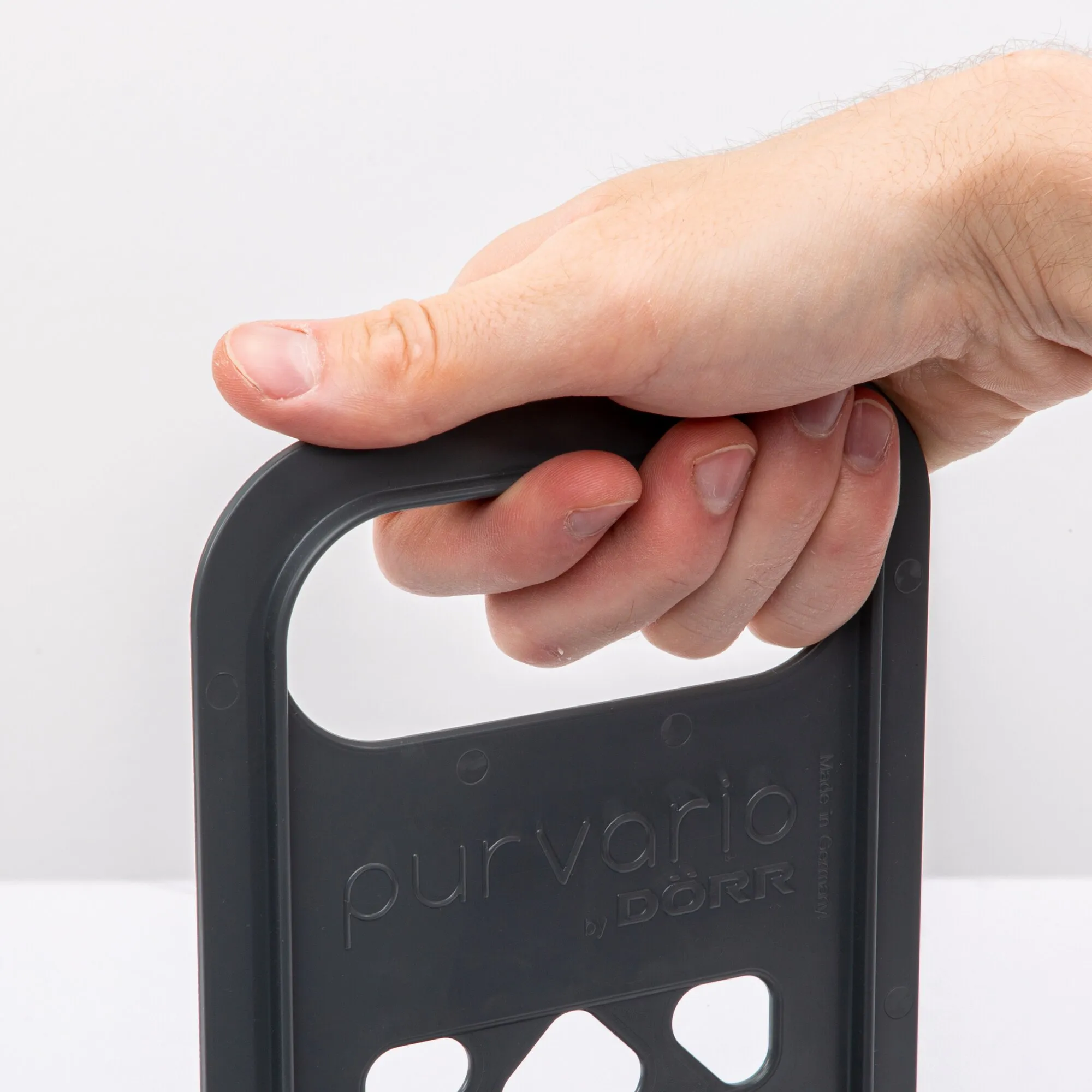 Hand hält den rechteckigen Flaschenhalter Multi Tray OELE und drückt auf dessen abgerundeten Rand