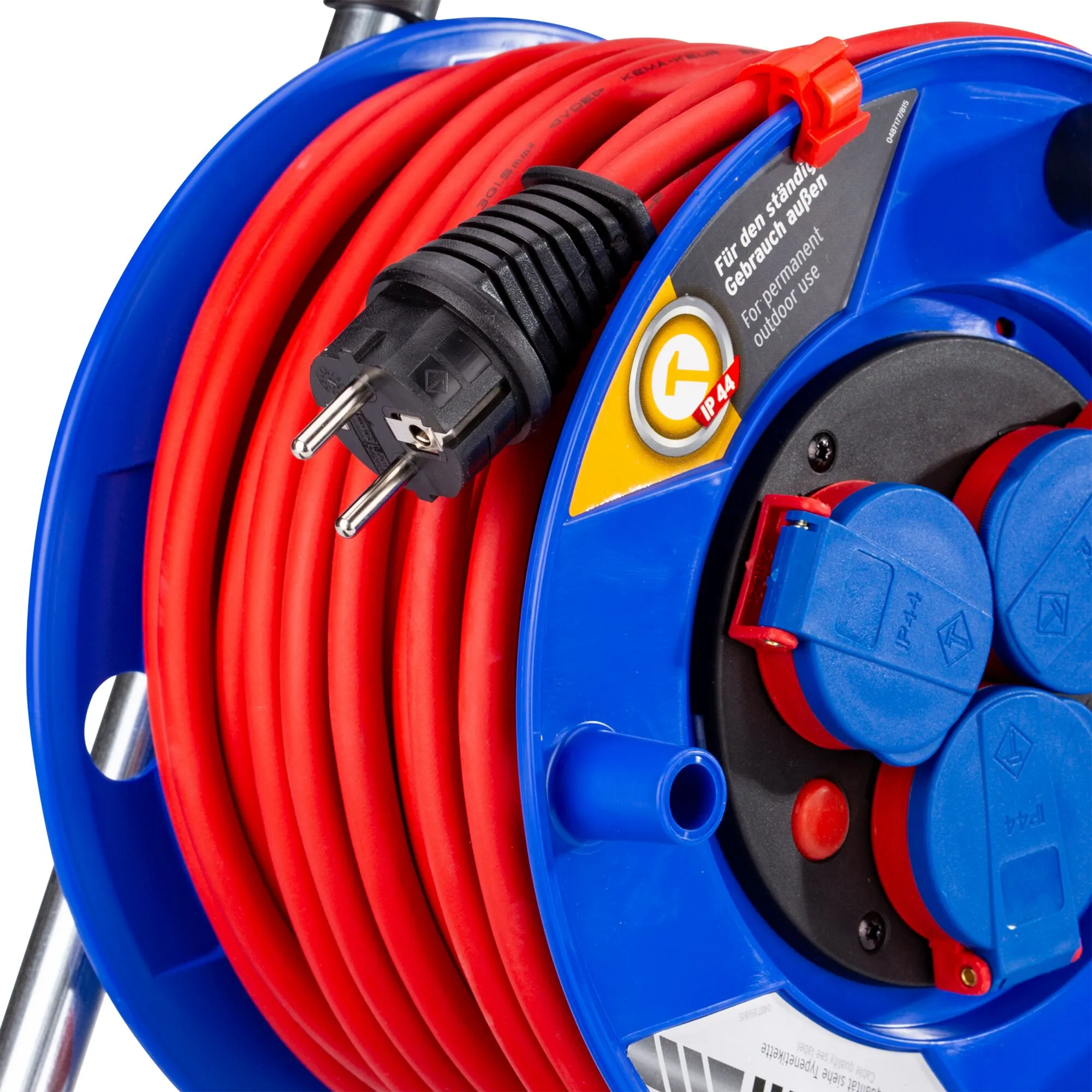 Detailaufnahme einer blauen Kabeltrommel mit aufgewickeltem rotem Kabel, Schuko-Stecker, vier Schutzkontaktsteckdosen und IP44-Kennzeichnung