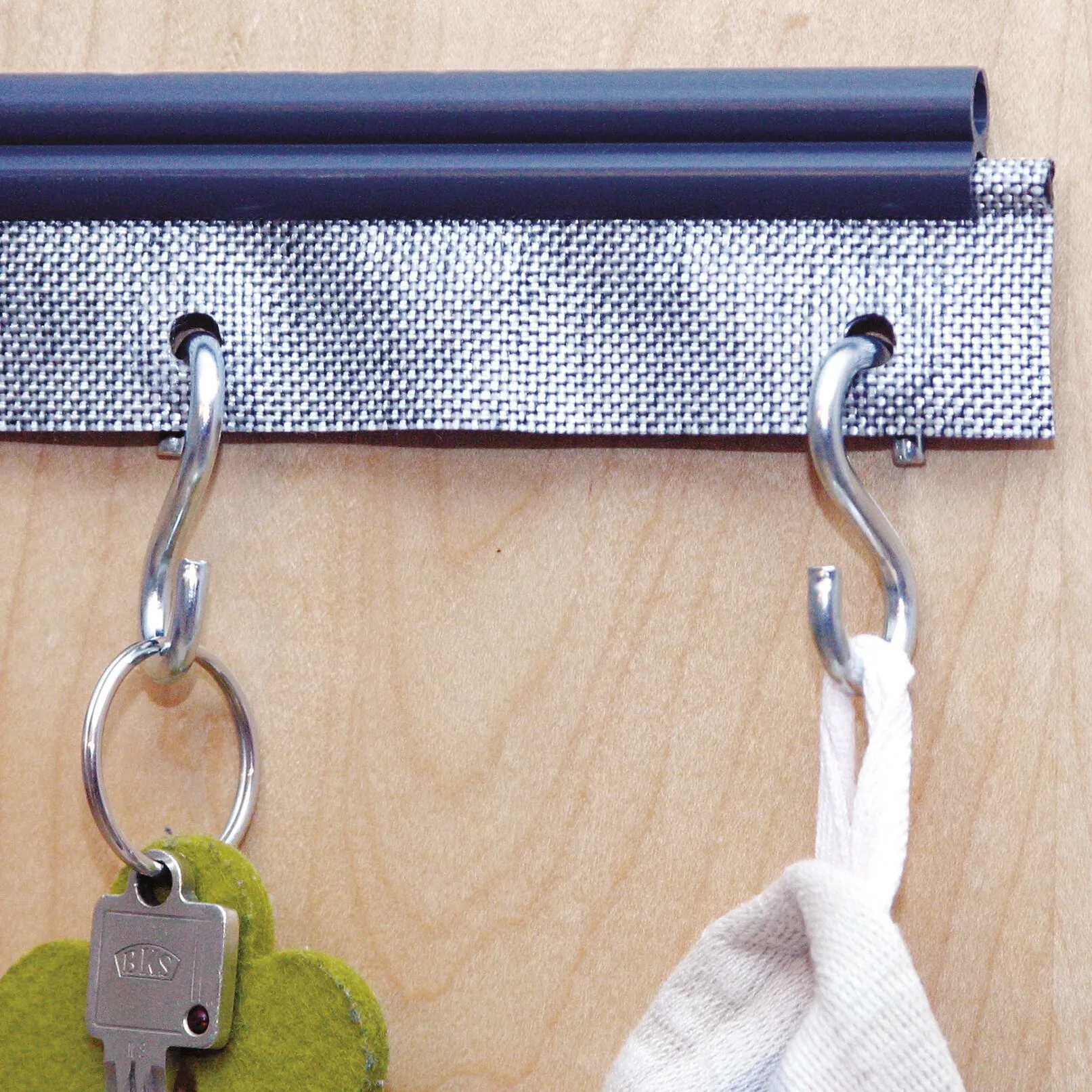 Multifunktionskeder mit schwarzem Kunststoffprofil, silbernem Gewebe und Metallhaken zum Aufhängen von Schlüsselbund und Stofftasche